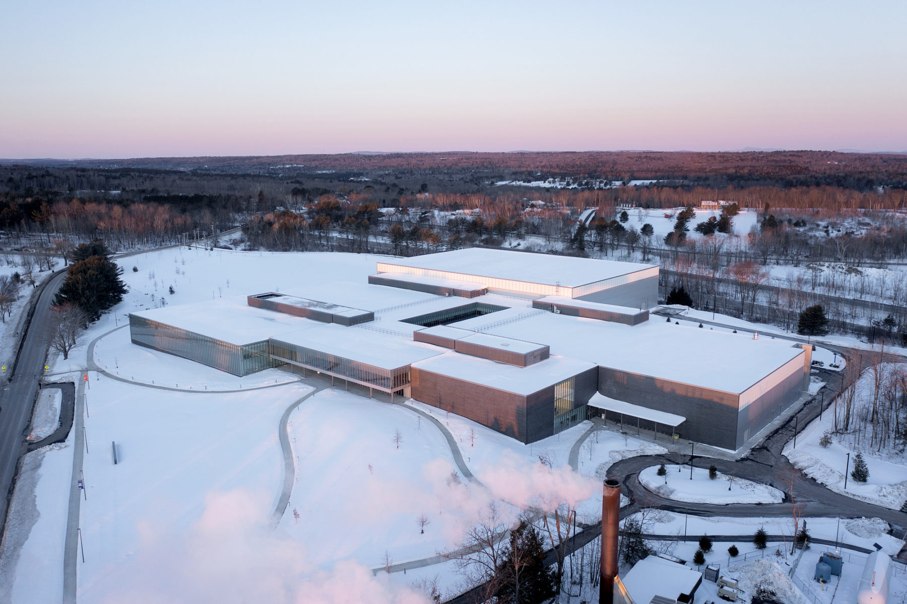 exterior aerial photo of building at dusk - landscape is snow covered