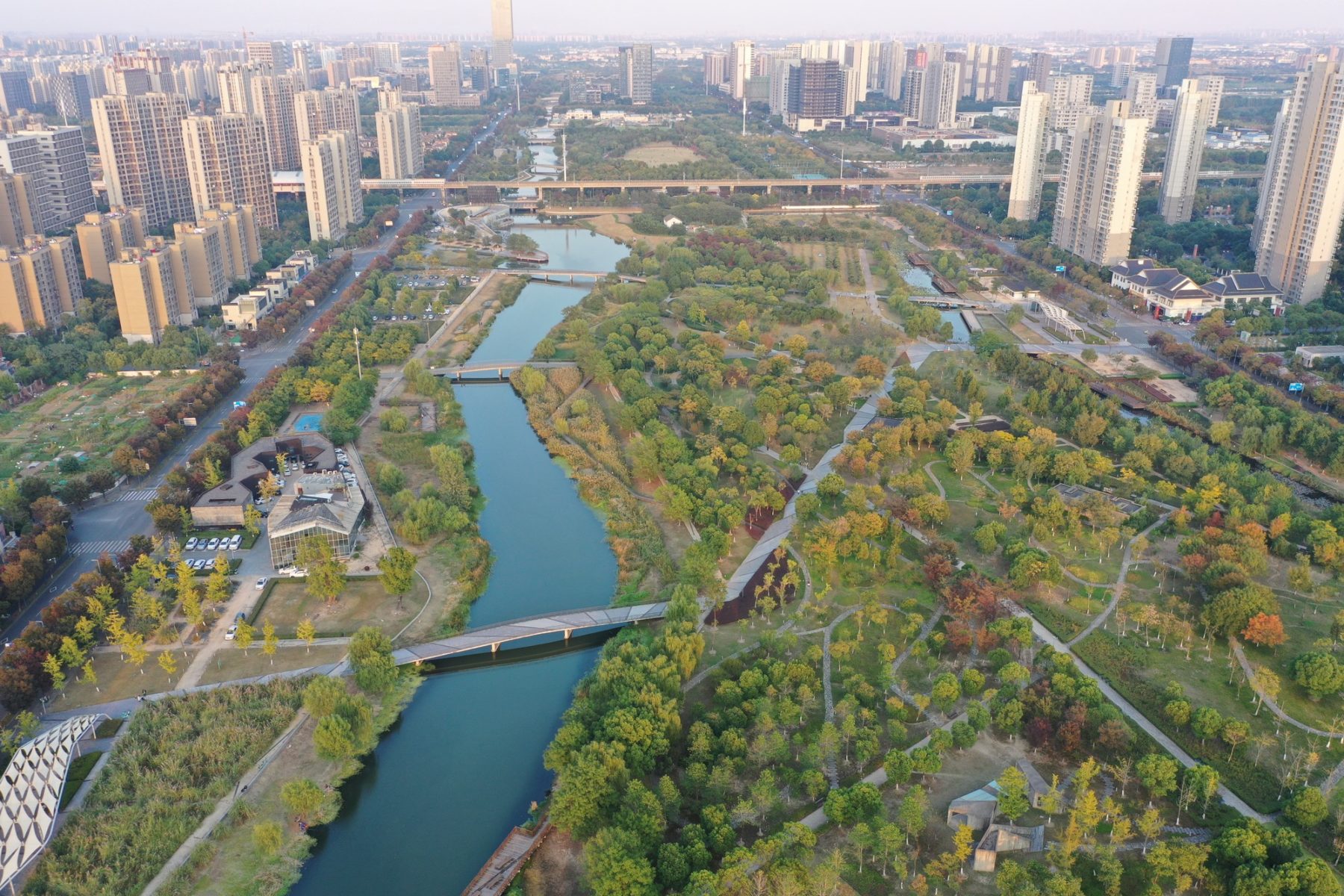 aerial photo of park looking down waterway with city context on either side