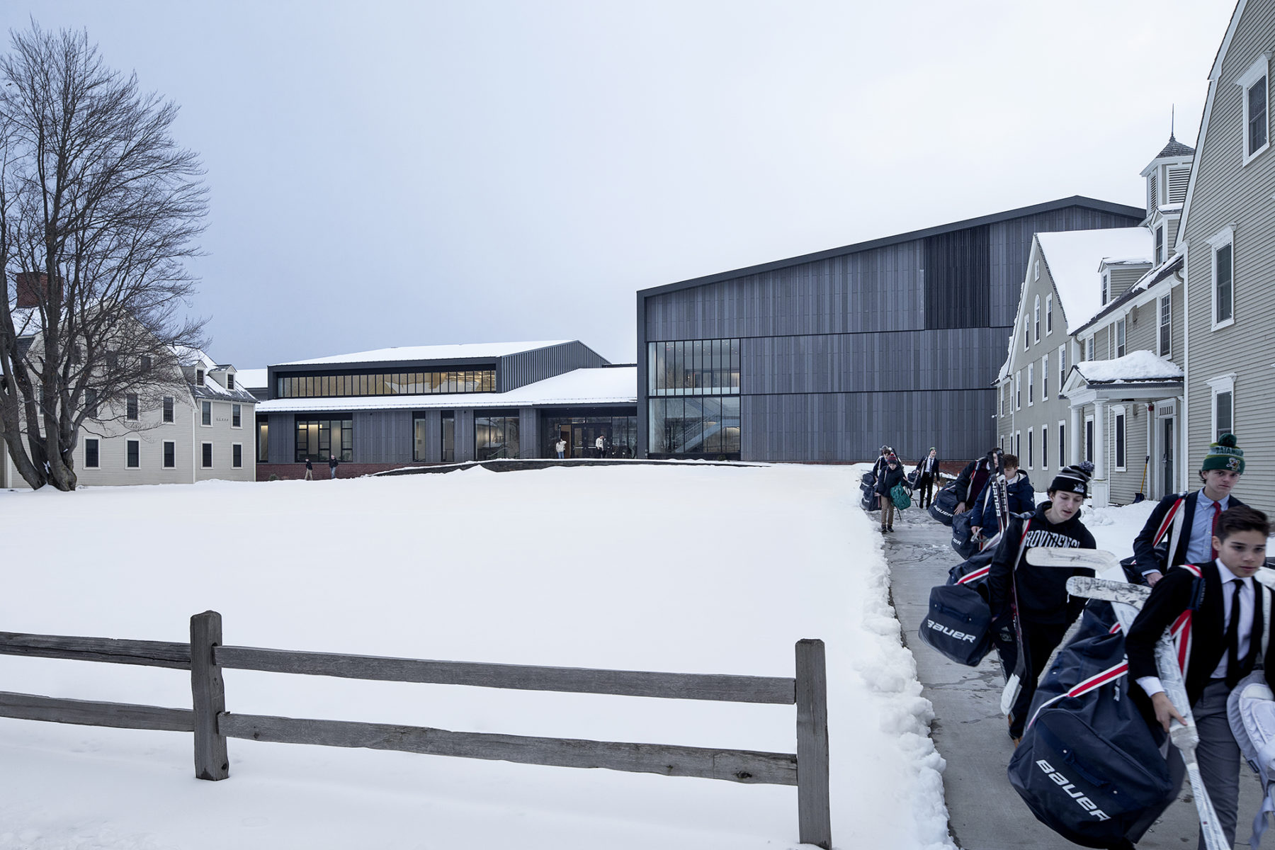 hockey players walking from field house, snow covering ground