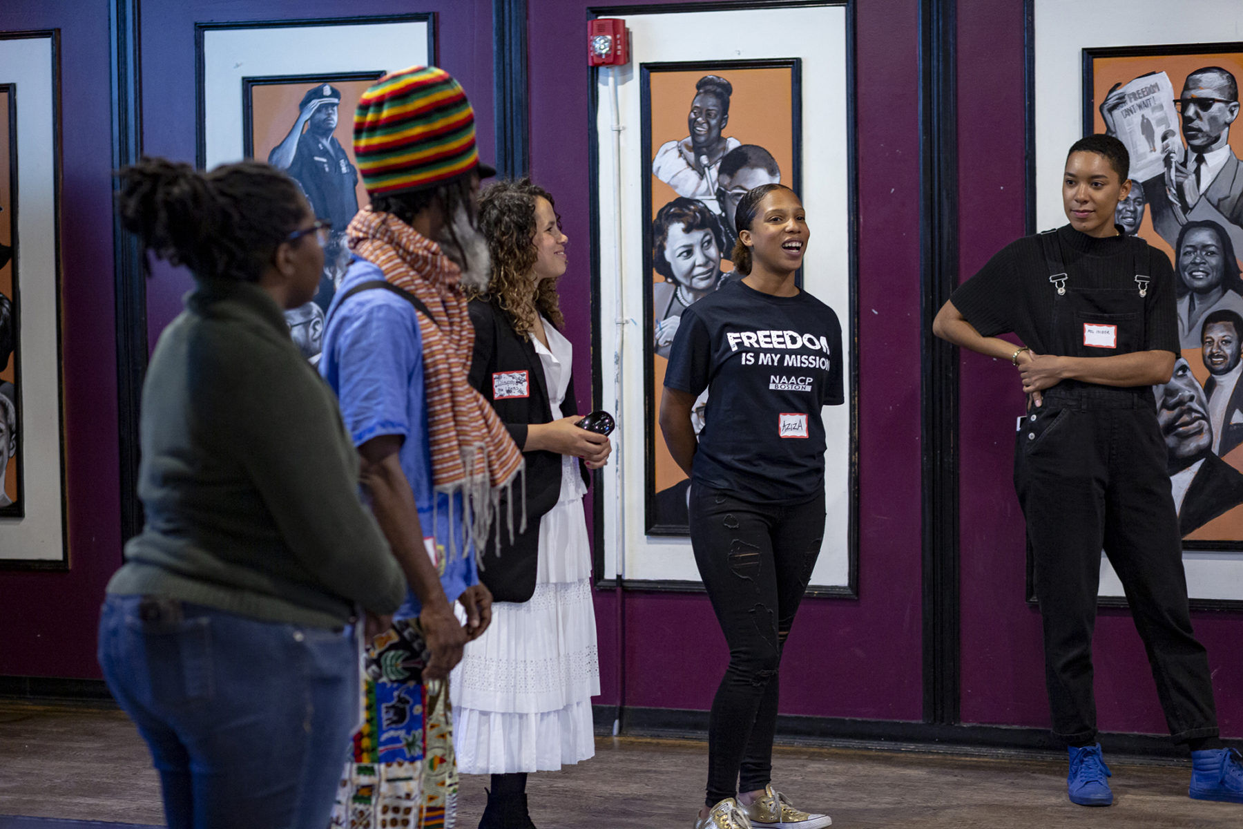 Five persons of color stand in front of a room discussing the Frederick Douglass Memorial project