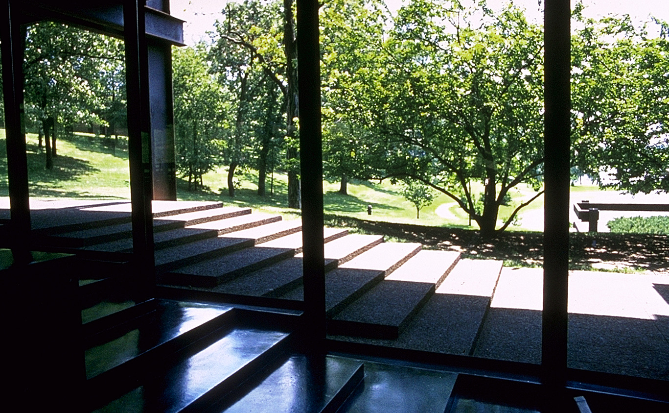 Photo from inside building looking outside to landscape and the amphitheater steps between the two