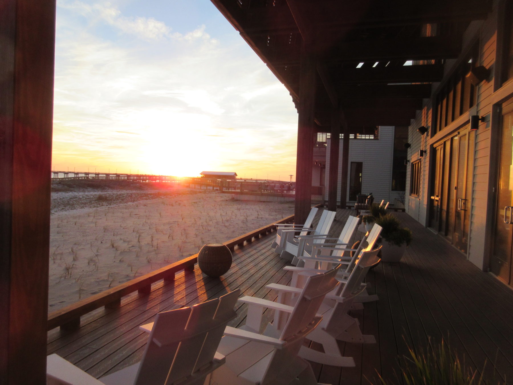 Adirondack chairs on a patio as the sun sets at Gulf State Park