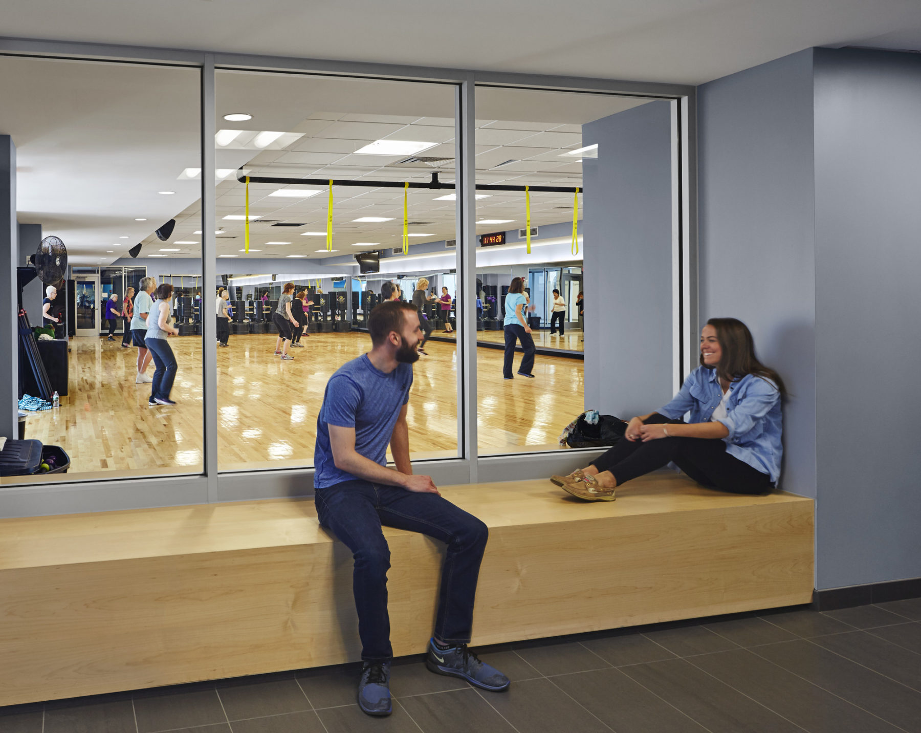 people on a bench outside of a workout room