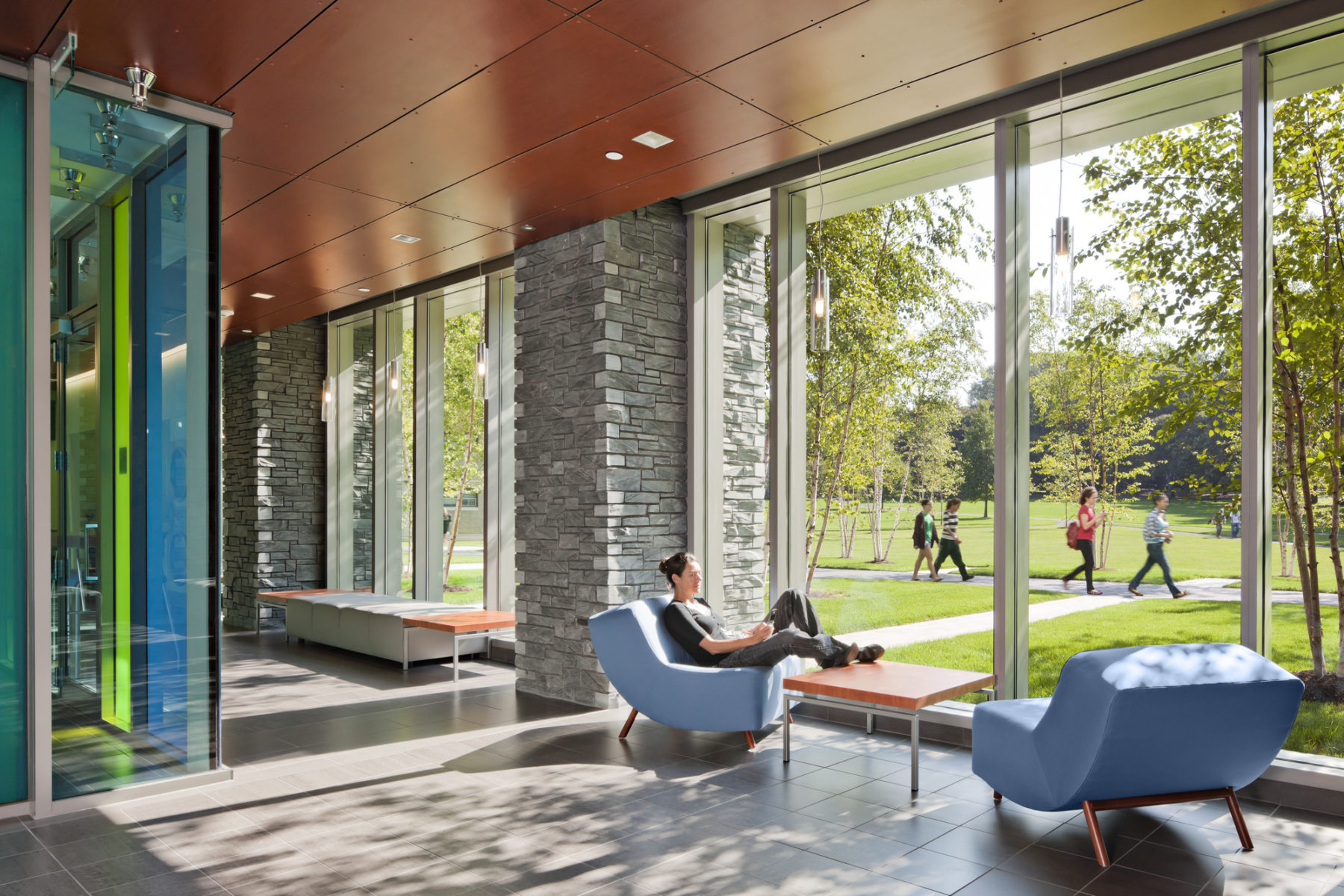 student sitting by large windows