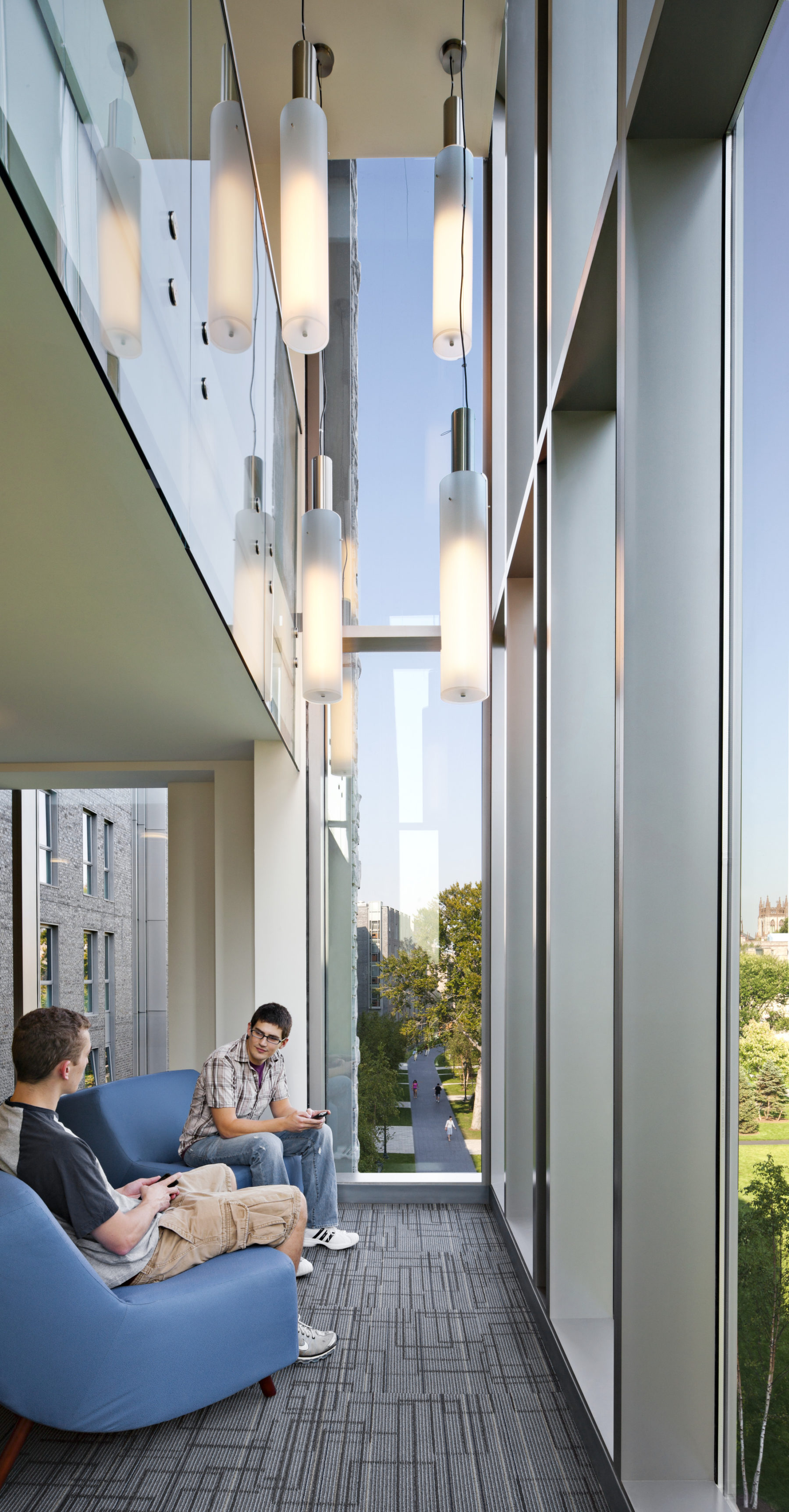 students sitting by large windows