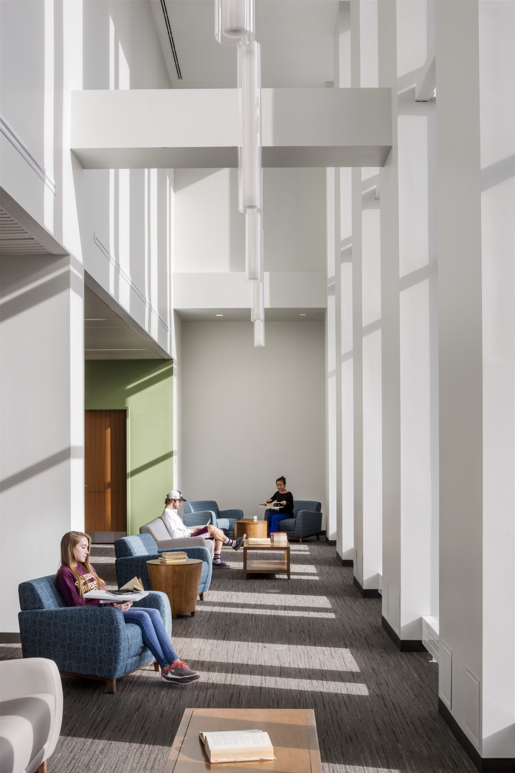 students sitting by windows in building interior