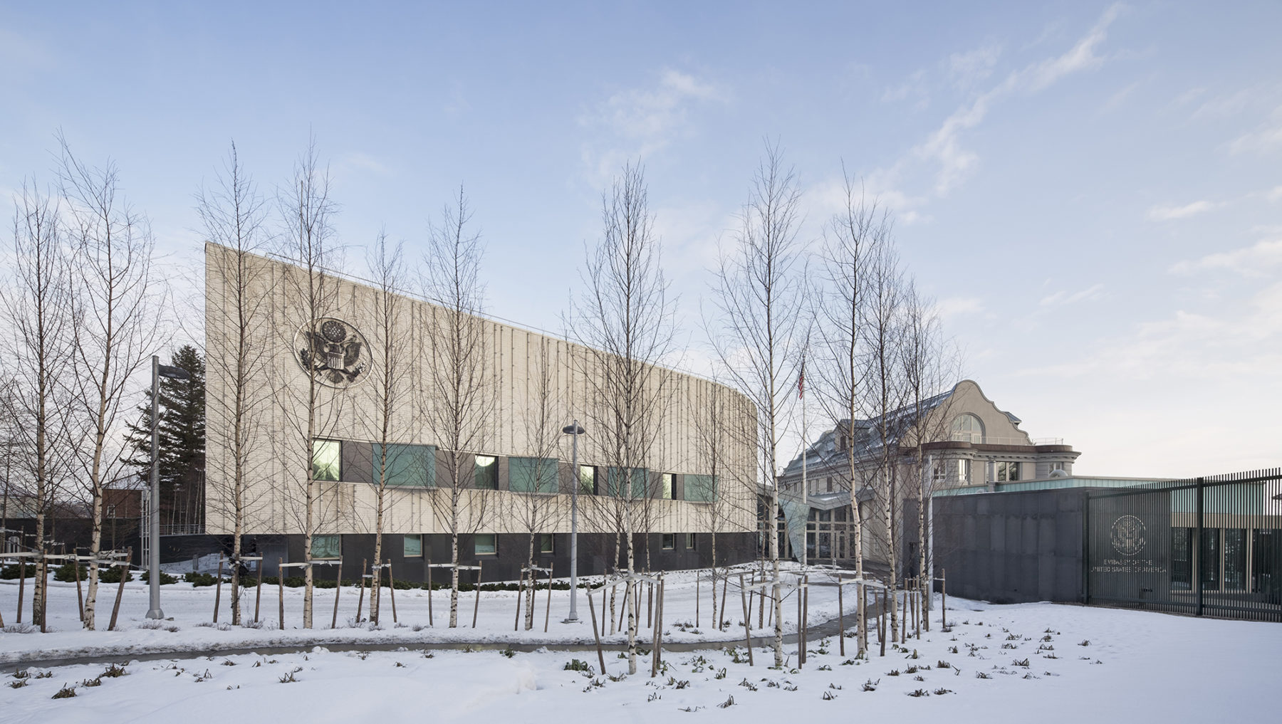winter photo of embassy showing snow on the ground and barren trees