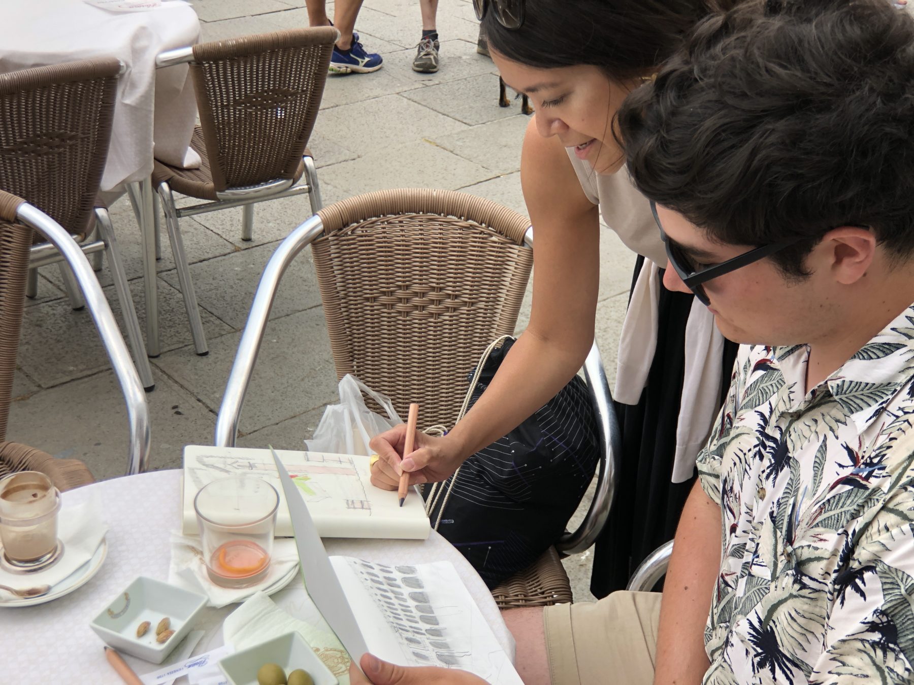 Ocampo and student in the foreground, they are looking at sketches.