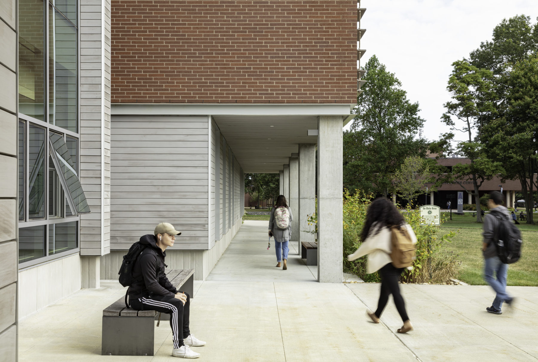 Students walking on the sidewalks directly outside of the building.