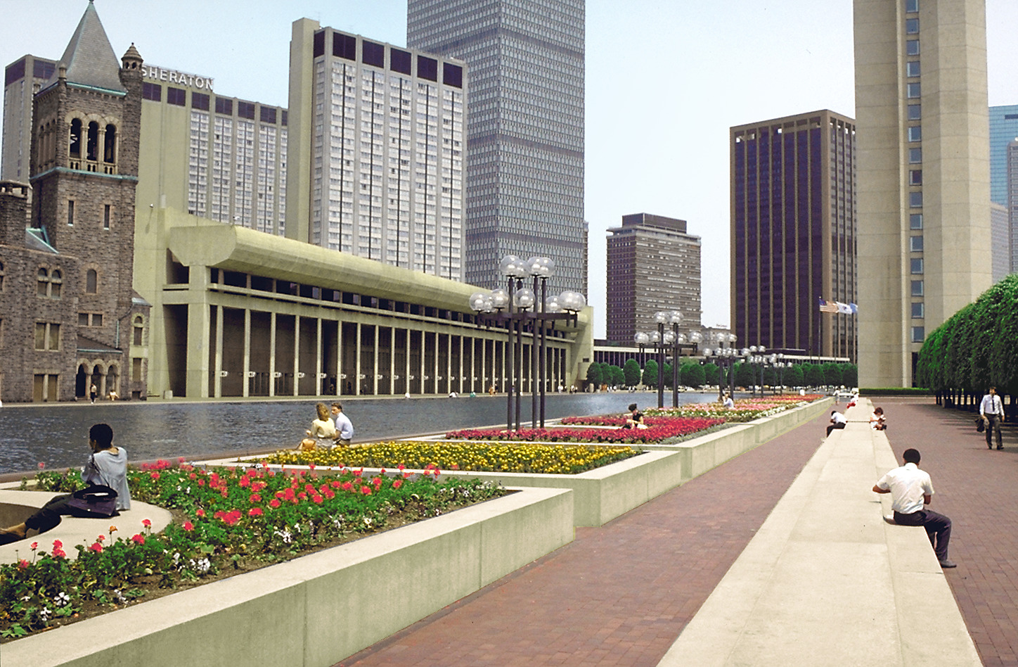 perspective photograph of square plantings with colorful flower beds bordering reflecting pool