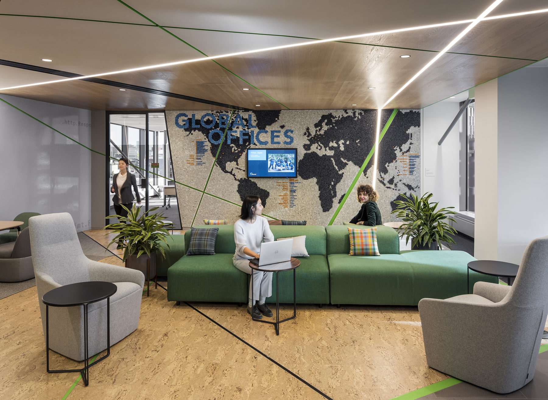 people sit on a couch in front of wall with a world map