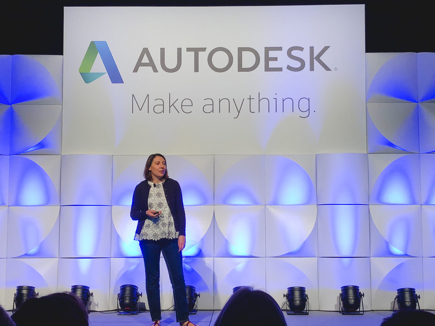 Designer speaks in front of large Autodesk sign on stage