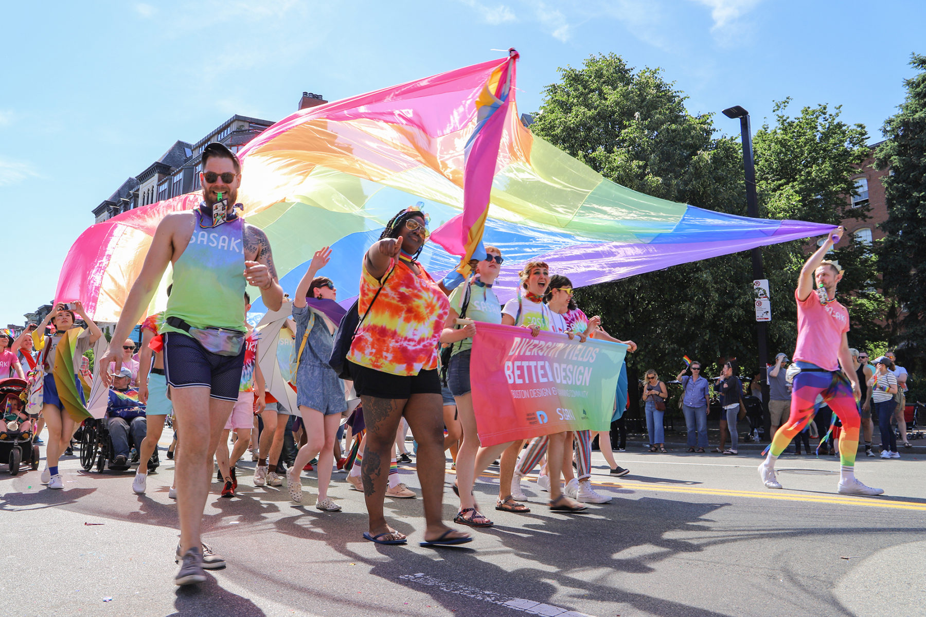 Sasakians marching in Boston's 2019 Pride Parade holding a flag overhead