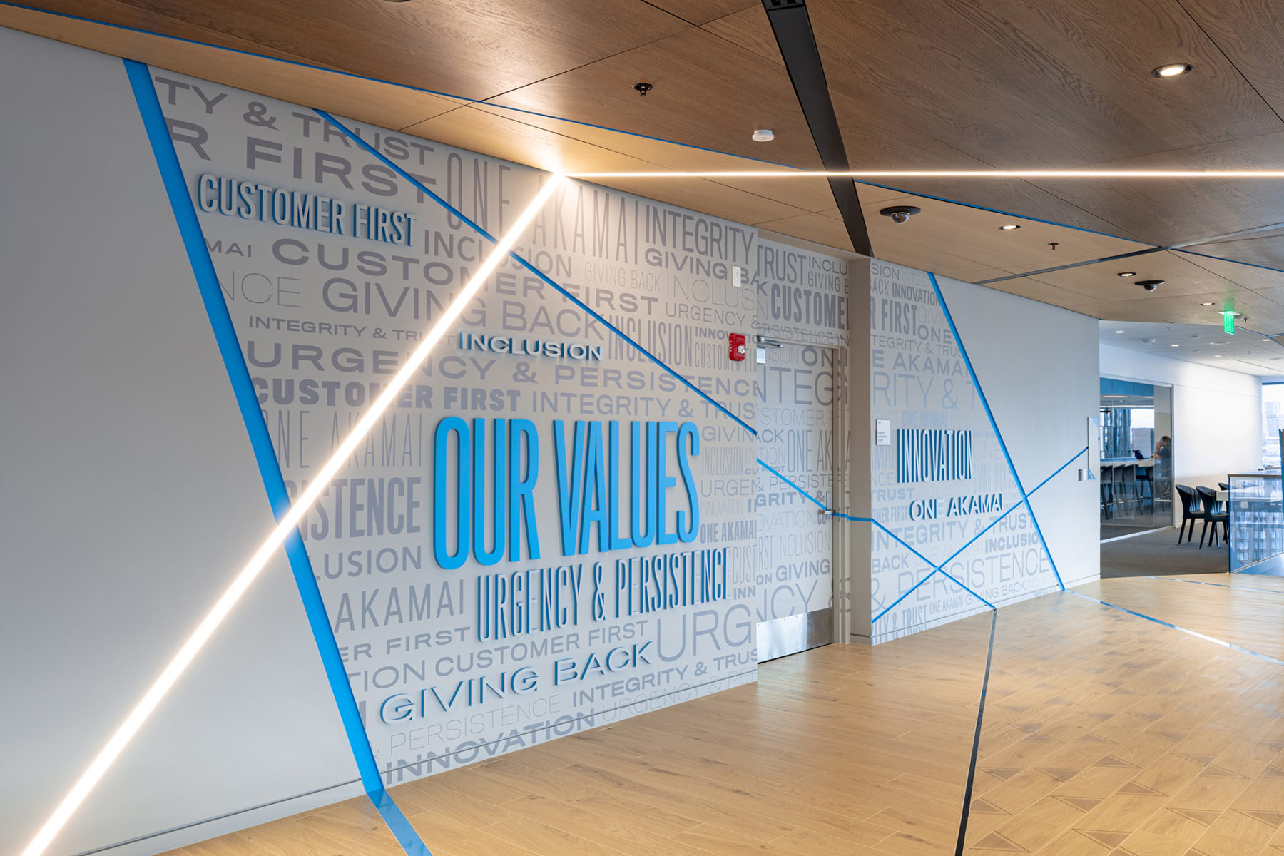 a wall covered in words that read Akamai's company values