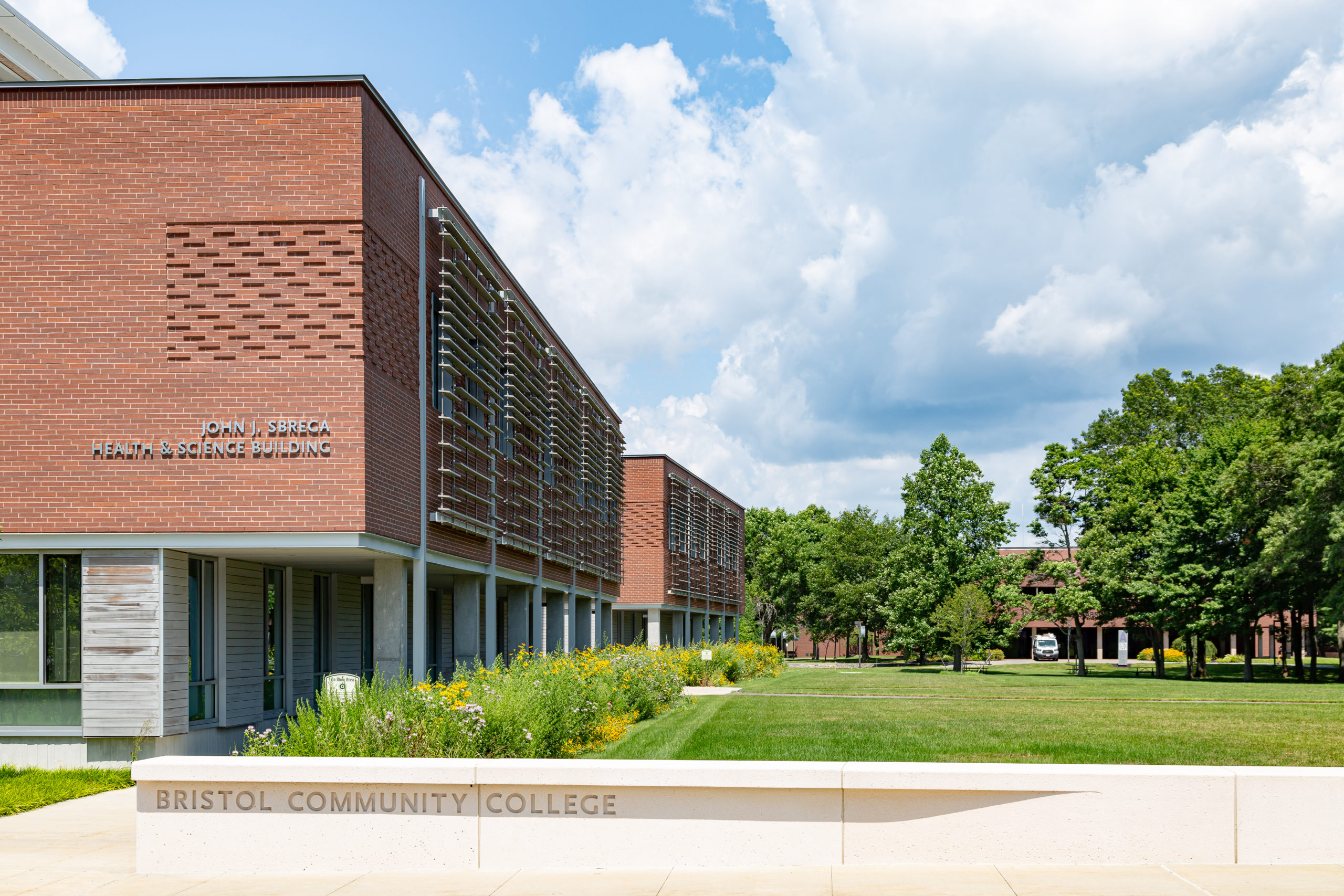 A view of the building featuring the natural and landscaped lawns.