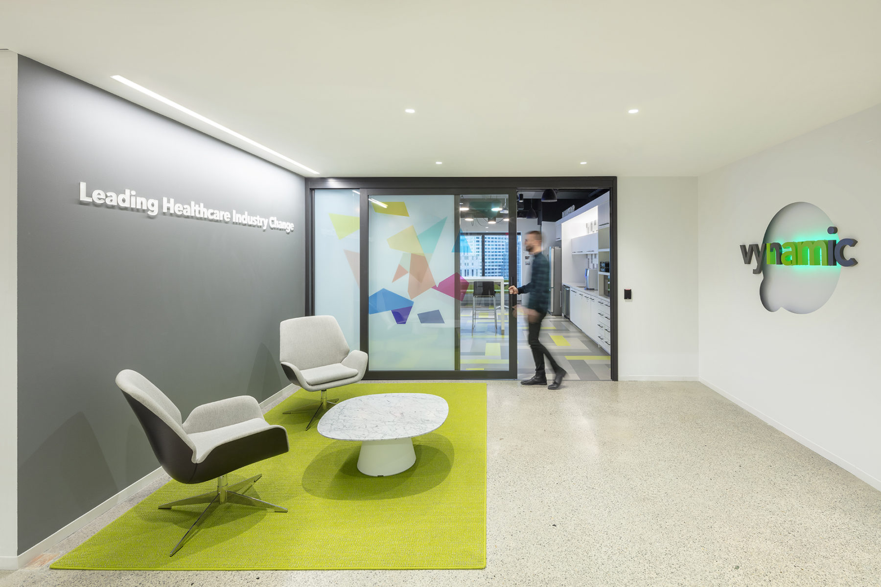 Entry lobby with sliding glass door showing Vynamic logo