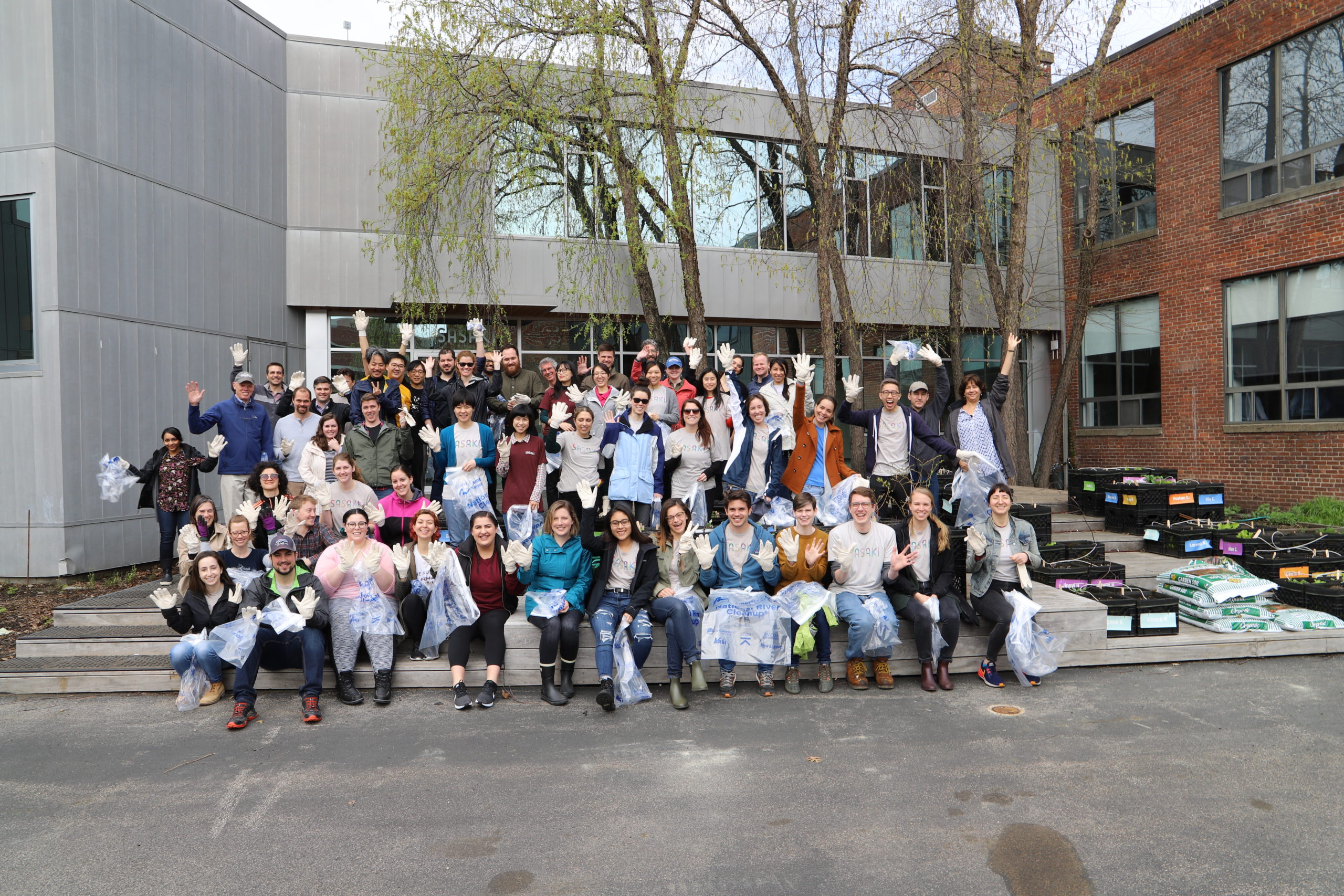 Group of people posing for a photo with their trash bags before the river clean-up event