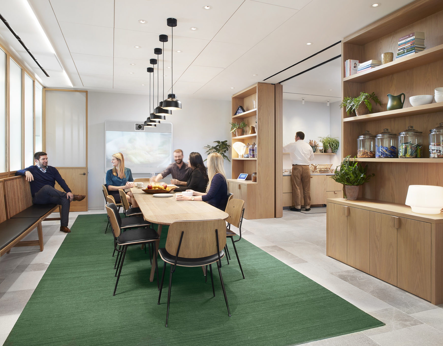 group meeting at common pantry table, cabinets and kitchen to right