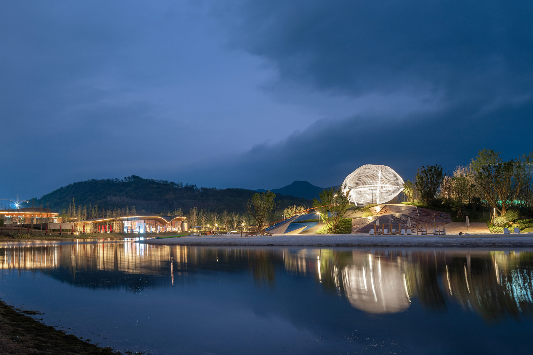 lit up structure on top of hill across body of water