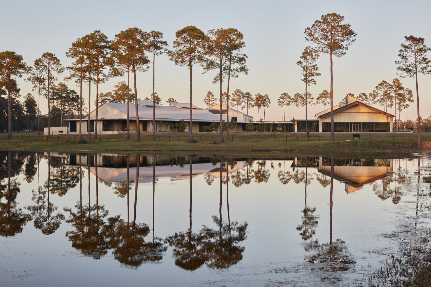 dusk photo of building from across pond with reflection