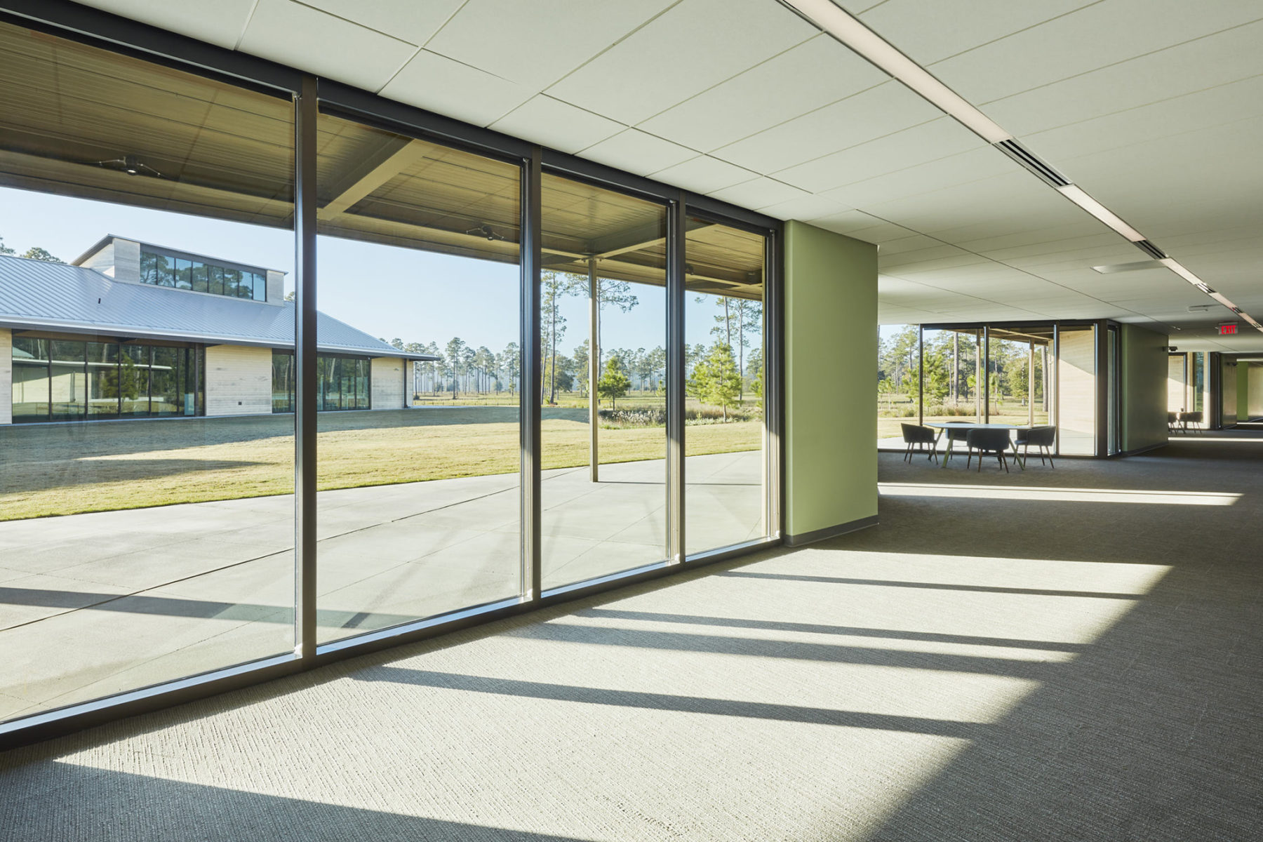 light streaming in full height windows, meeting area in the back for working