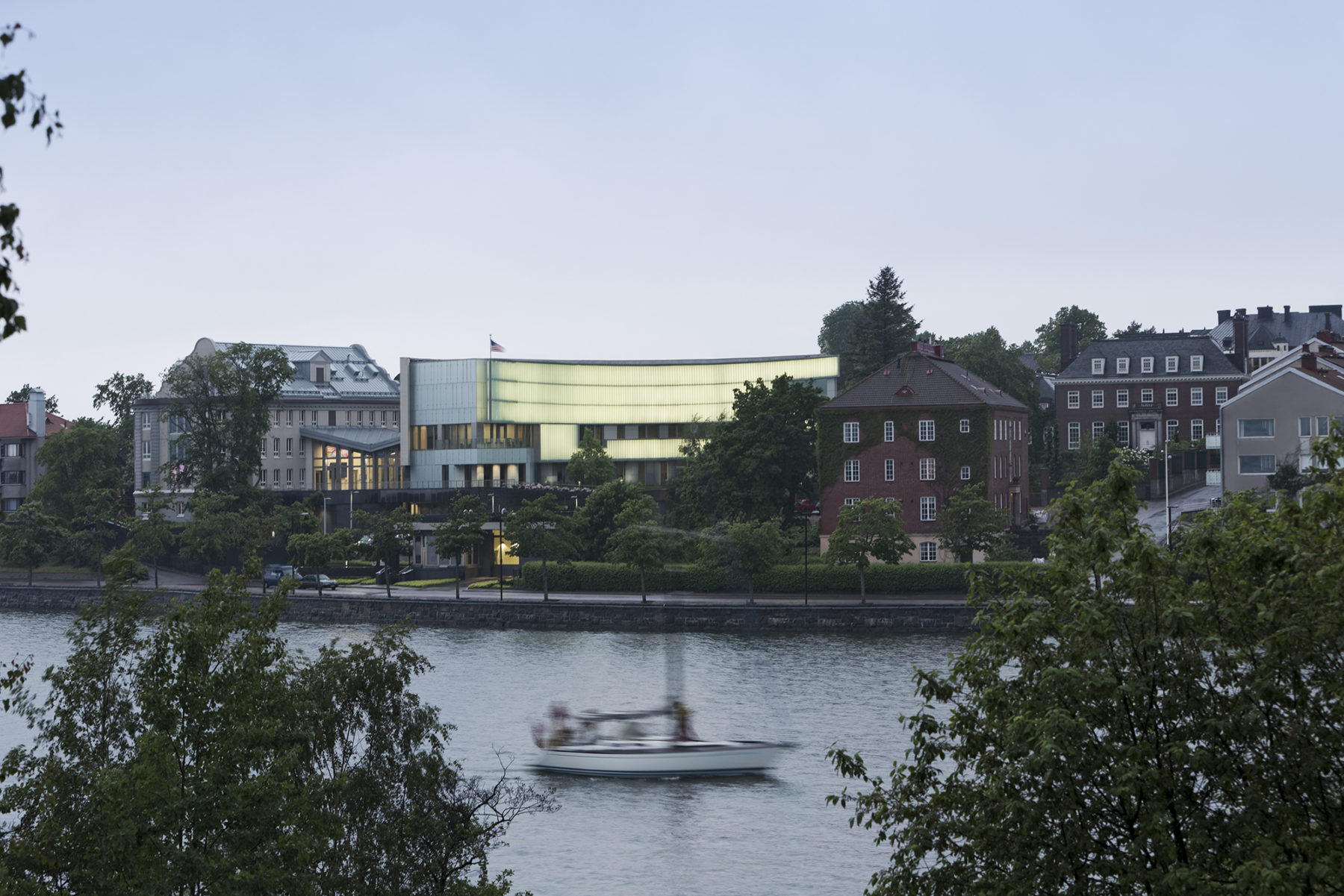 view of embassy from across water, boat in river