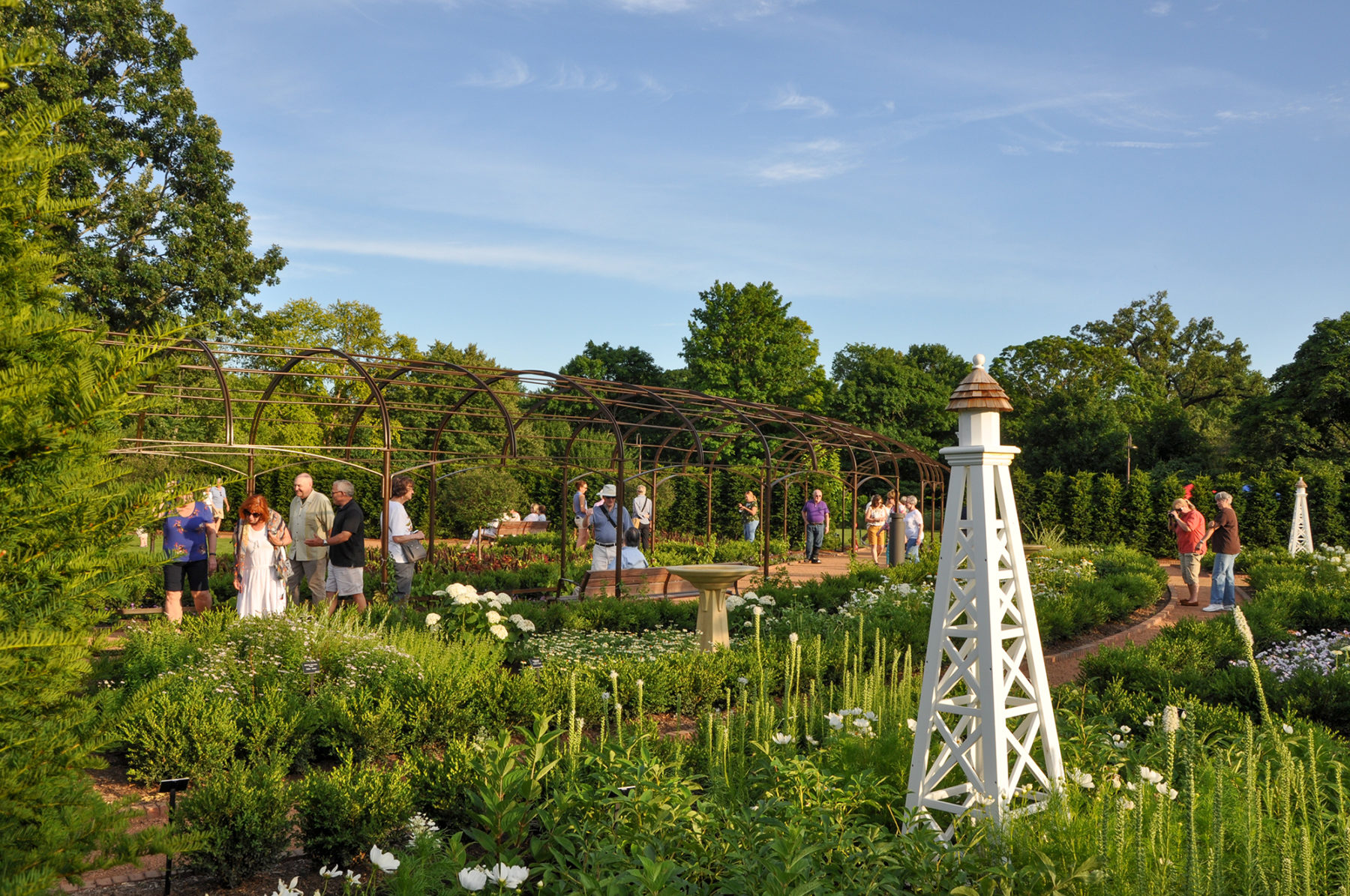 photo of people walking on paths through a garden