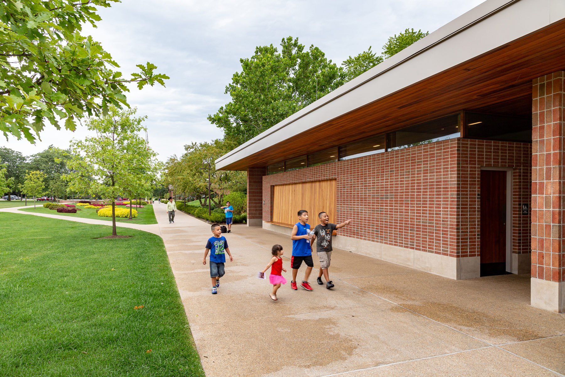 children run alongside a building