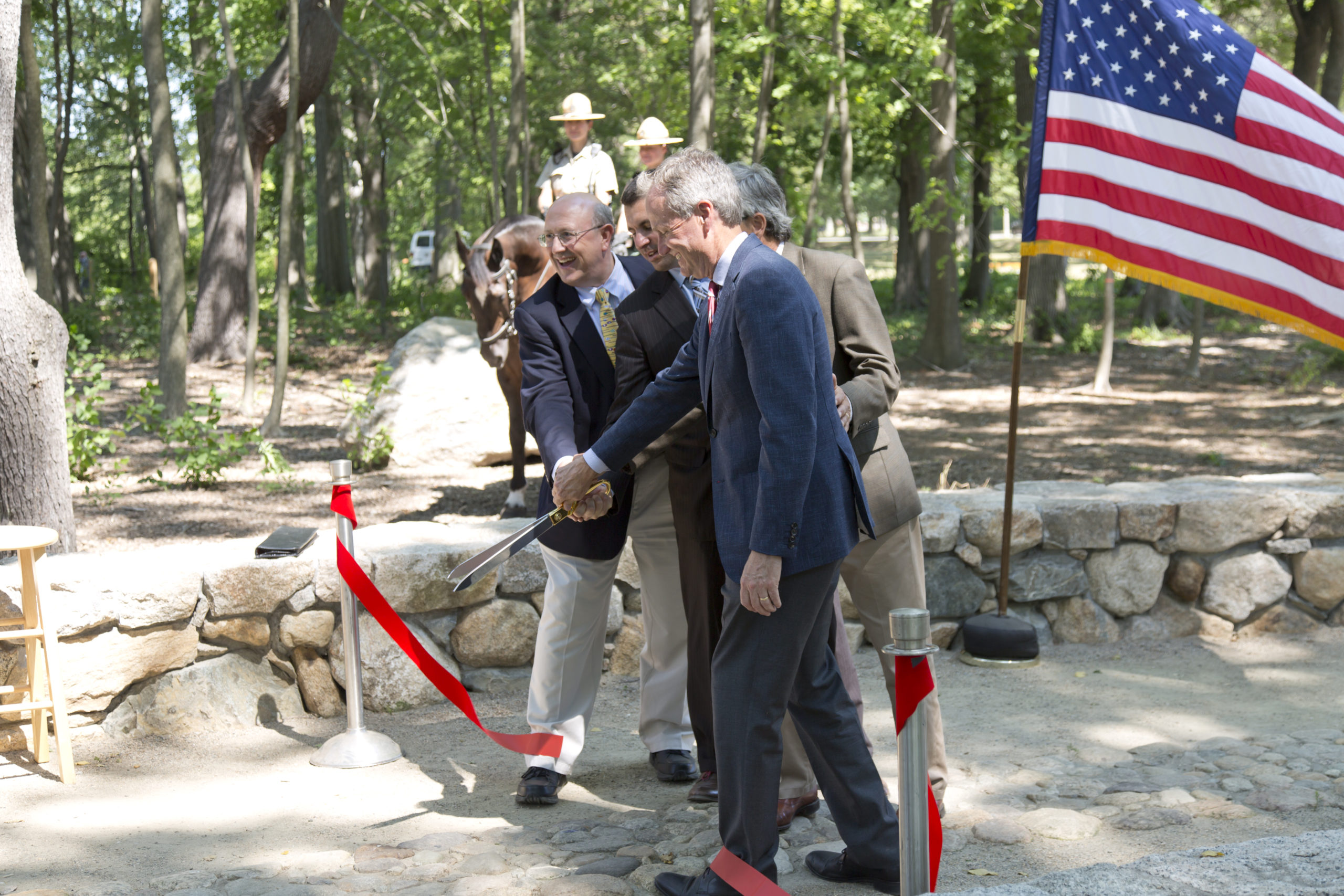 Two men cutting ribbon in sensory garden to open park