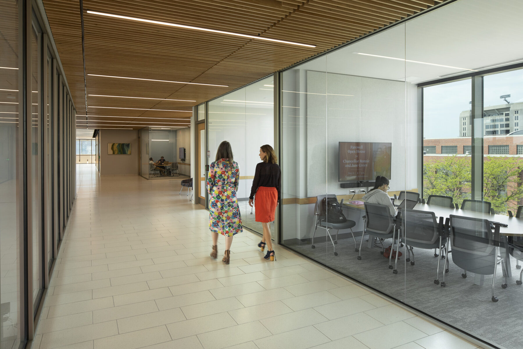 Interior photo of hallway view with small fully transparent breakout room enclosed in glass