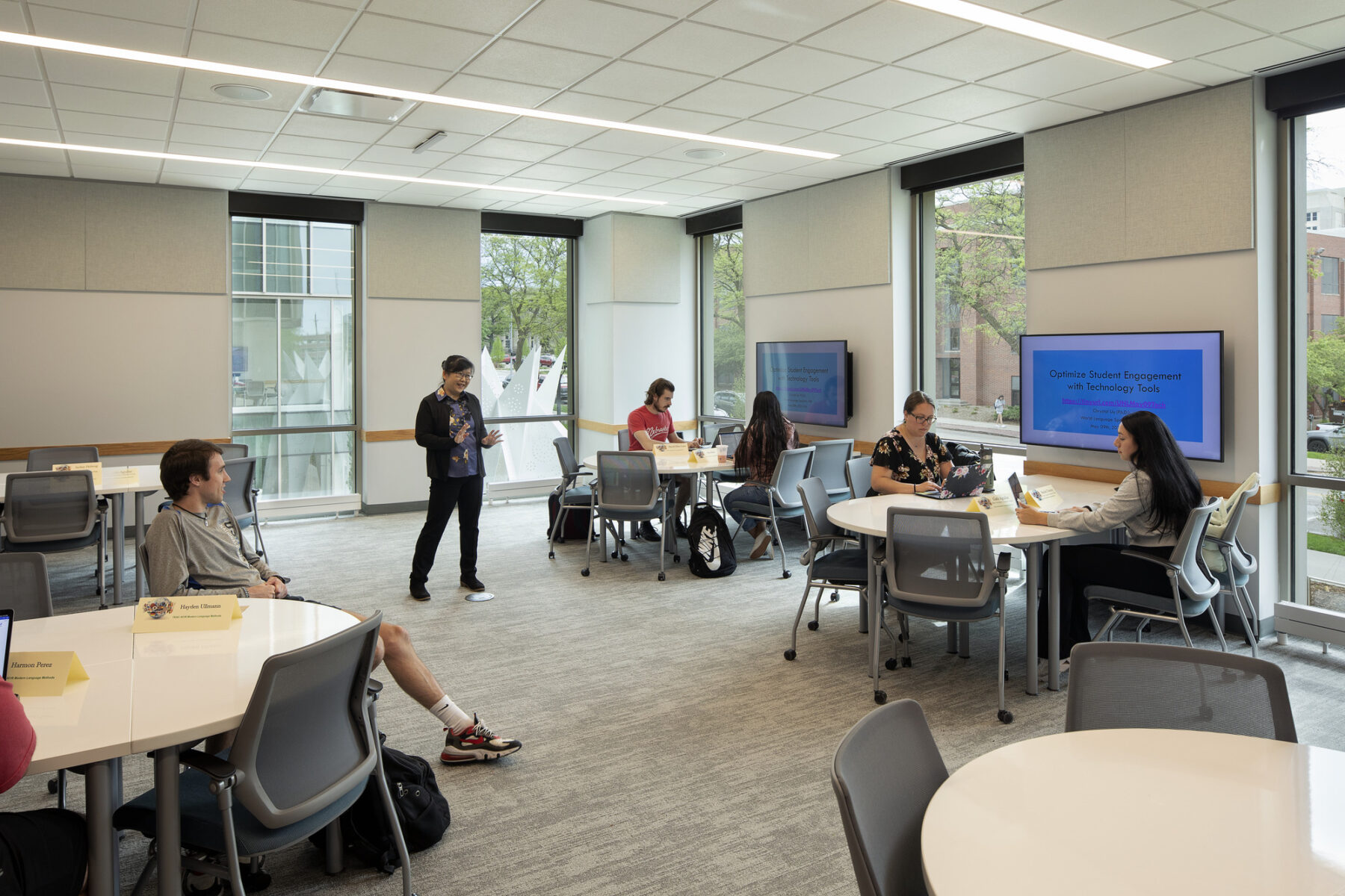 Photo of classroom interior organized with clusters of tables with small groups of students