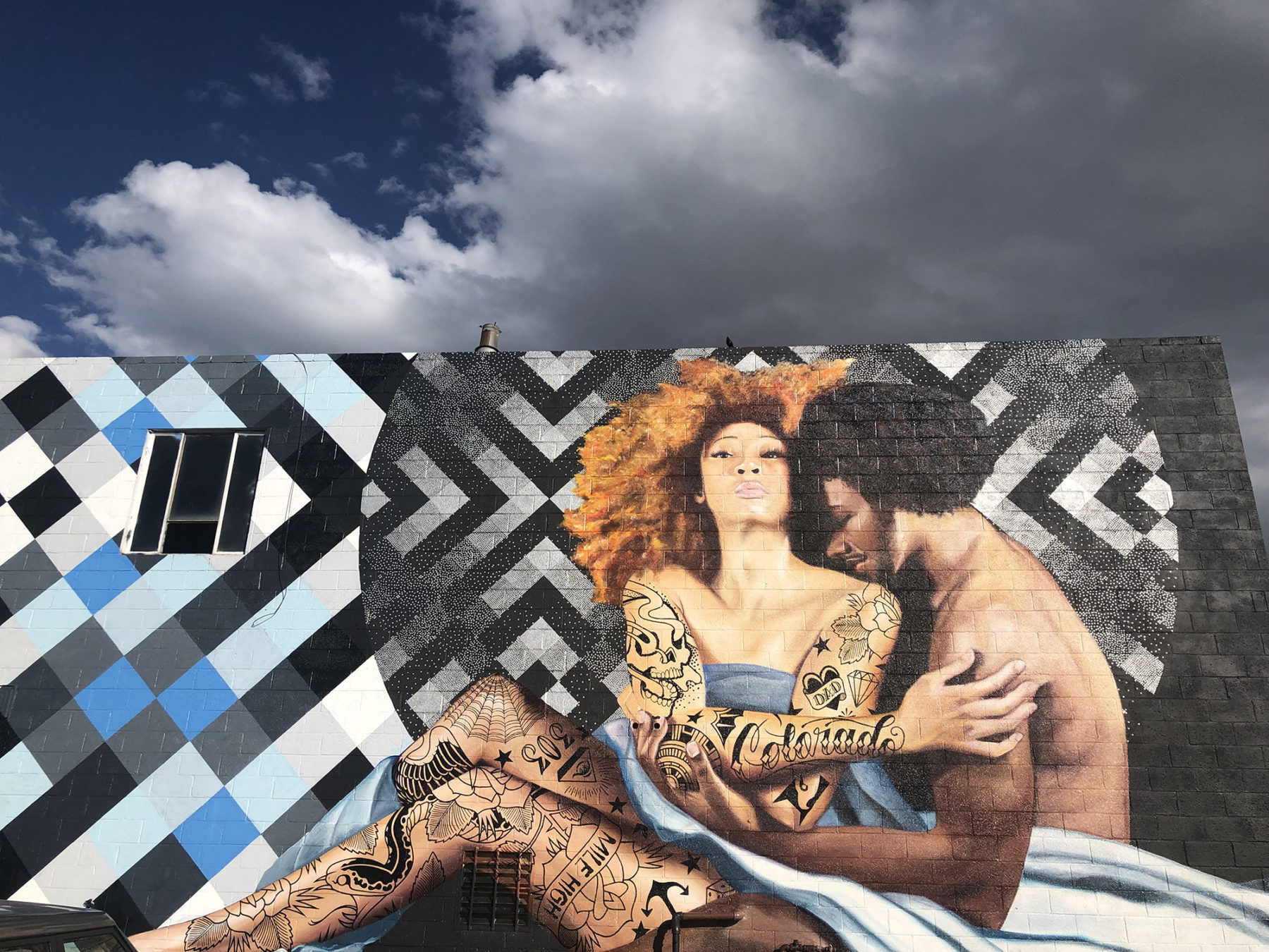 Mural of black man and women embracing on side of building