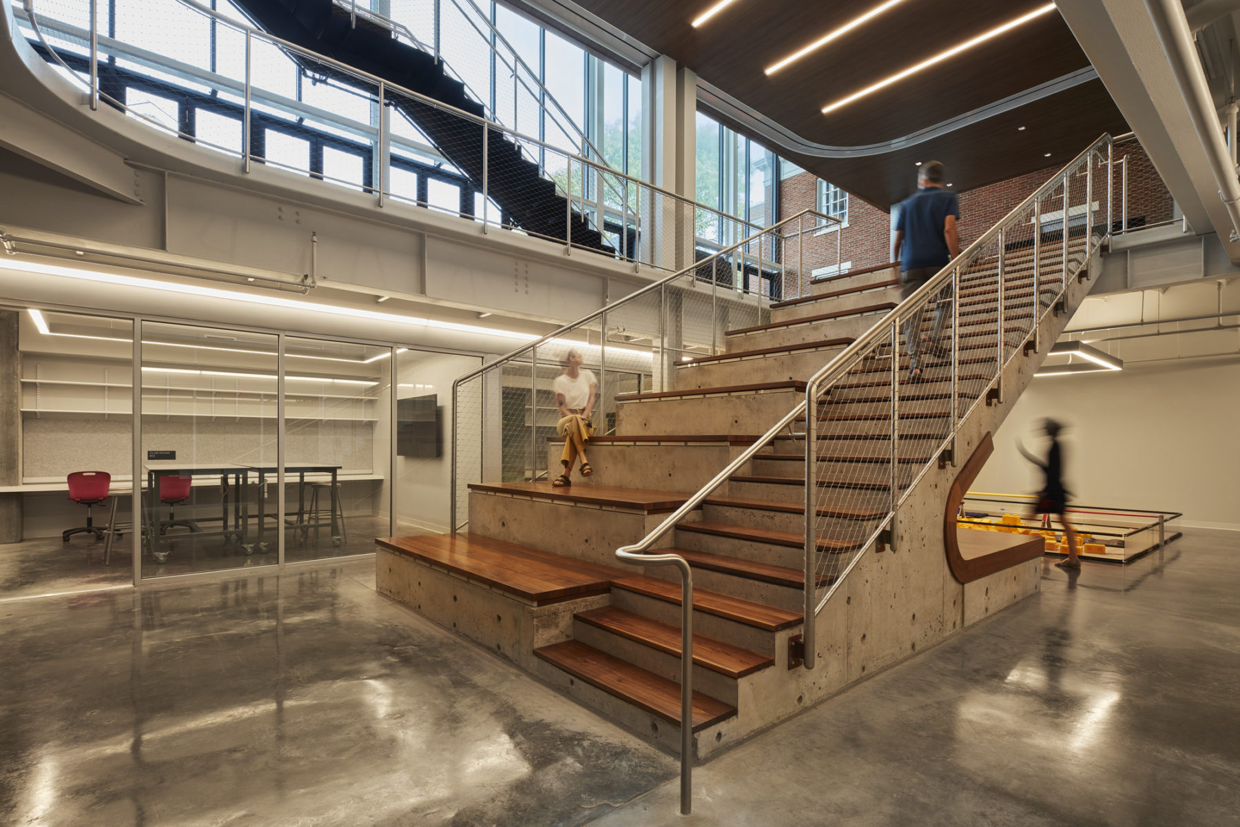 Interior photo at bottom of stairs, concrete stairs with wood