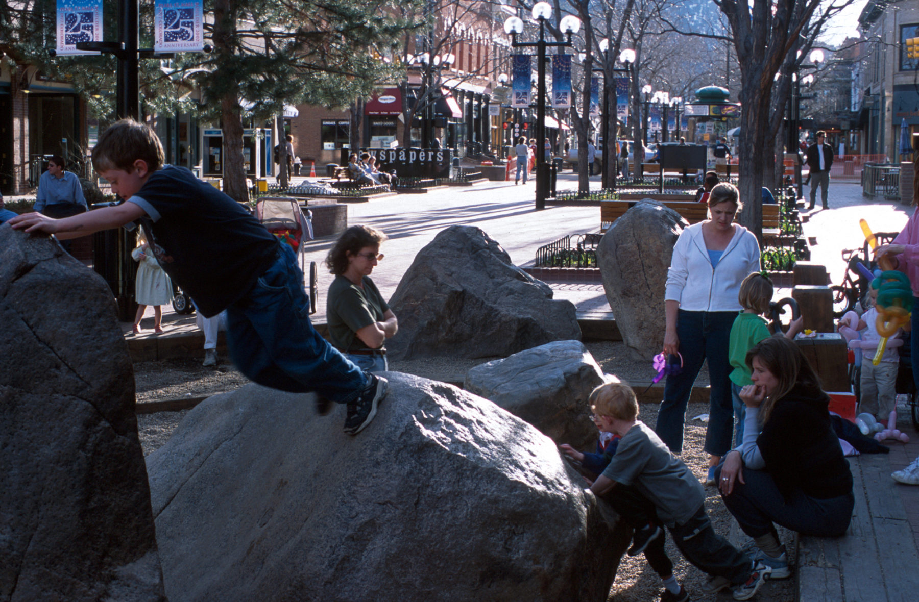 photo of children playing on boulders along the pedestrian mall