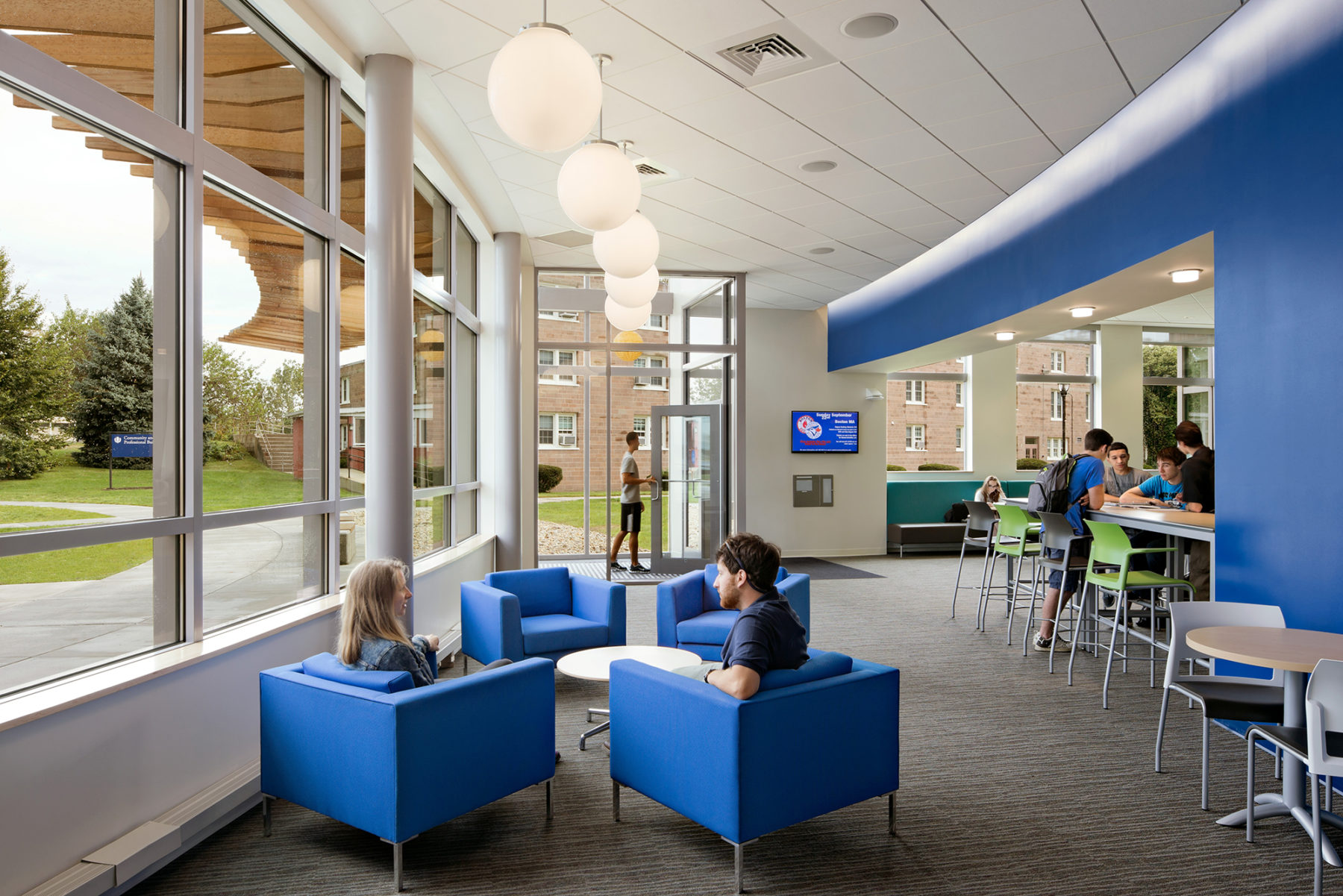 Interior photo of students sitting in lounge chairs