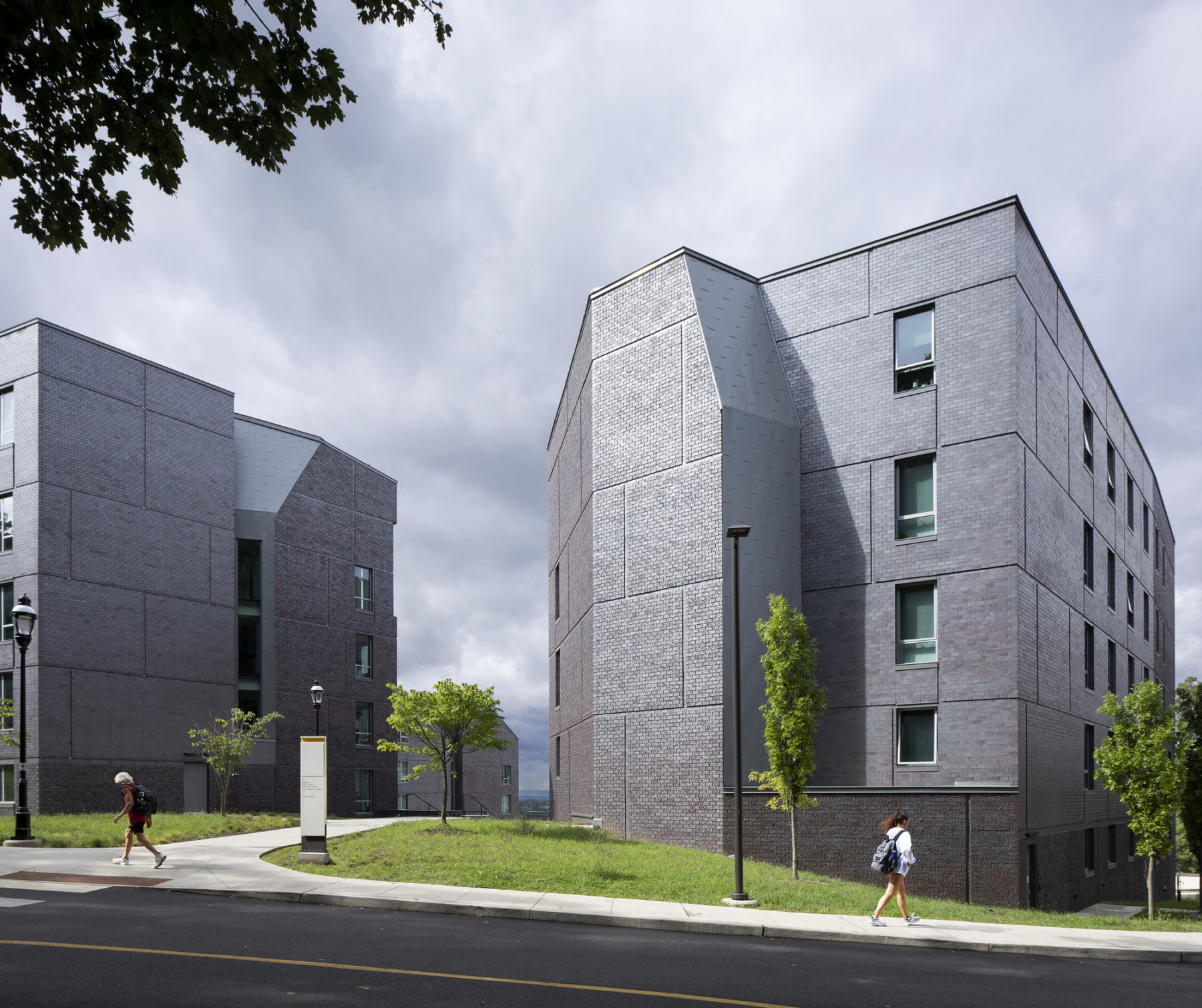 exterior photo of buildings. two students walk on a path nearby