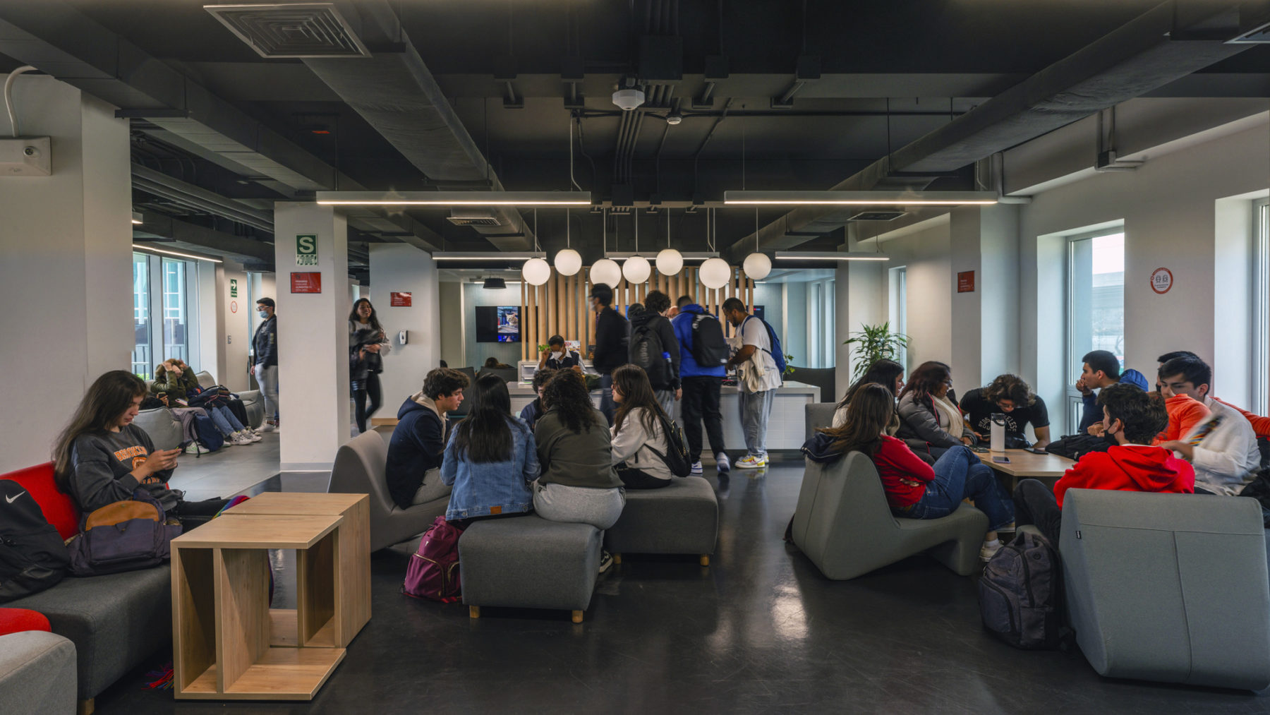 interior photo of student lounge with groups of students lounging on soft seating