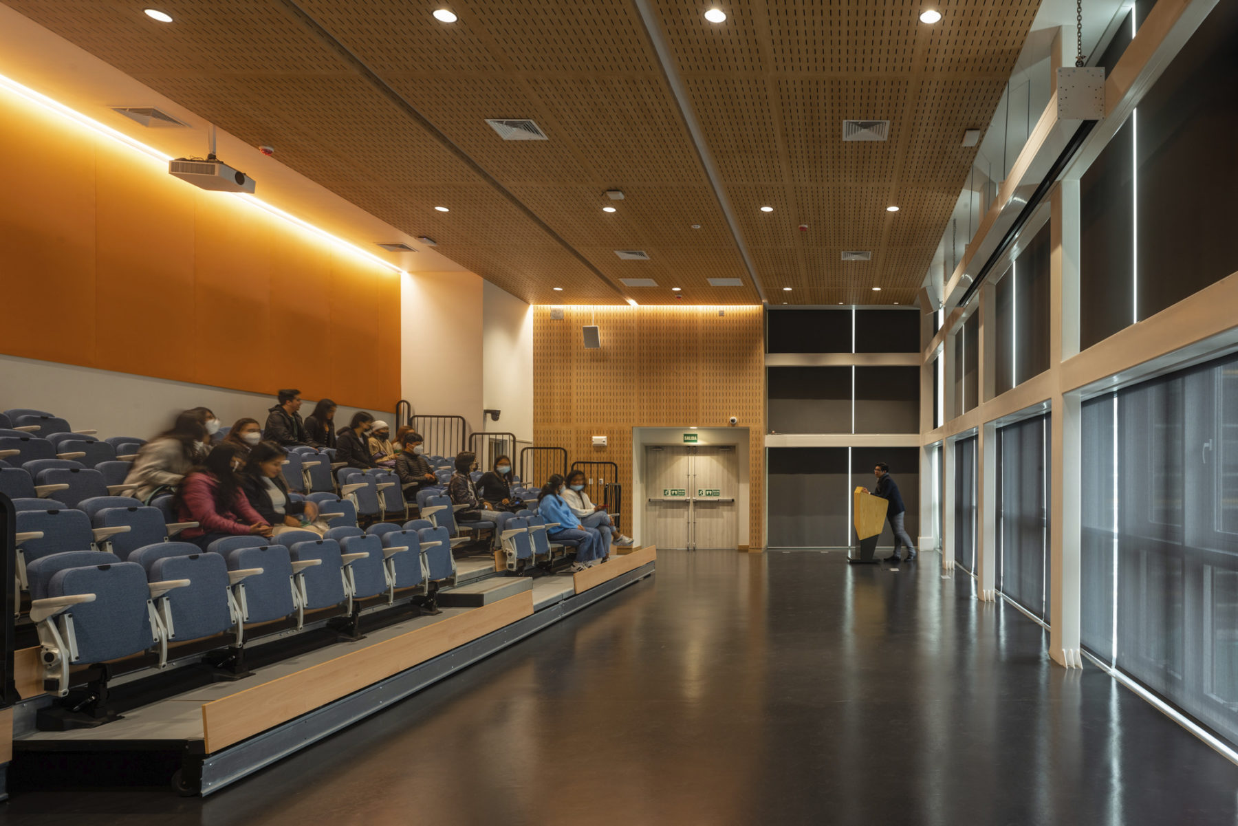 interior photo of flex theater with students sitting in blue theater seats