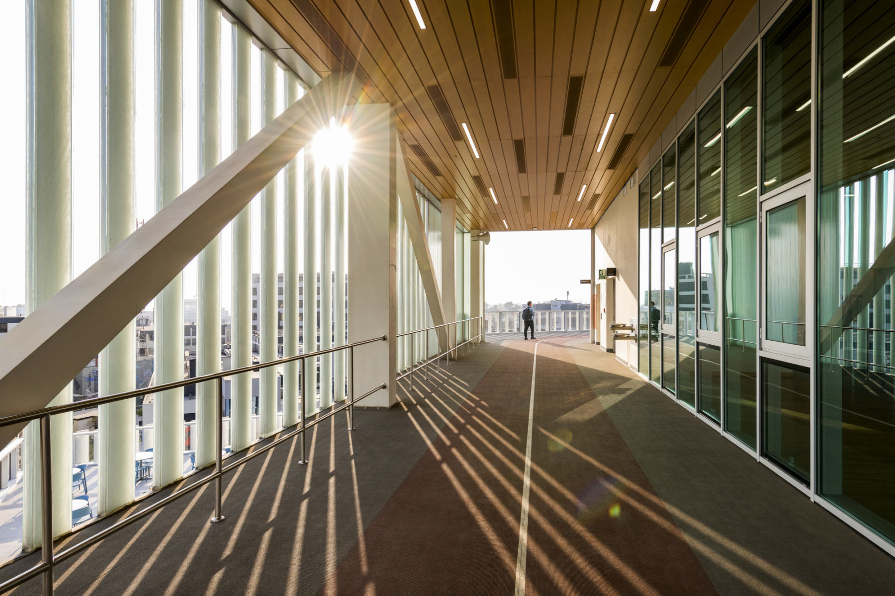 exterior photo of elevated outdoor track, sunlight streams in through building enclosure