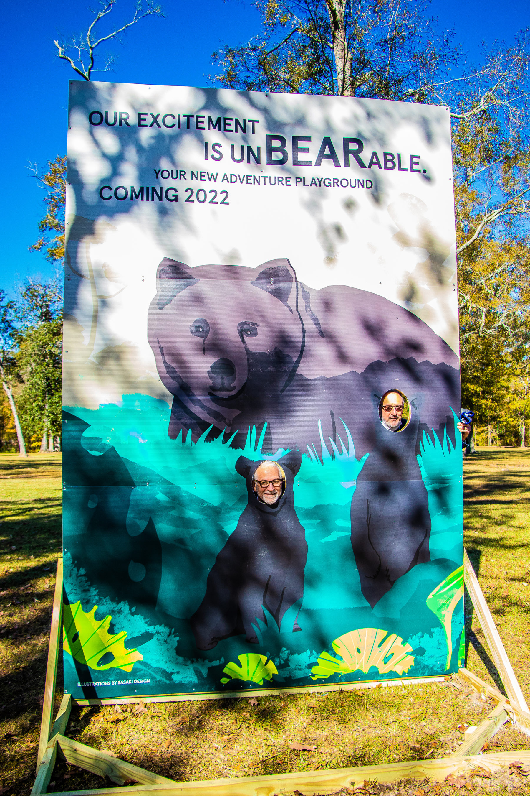 people putting their heads through holes in an illustrated cutout