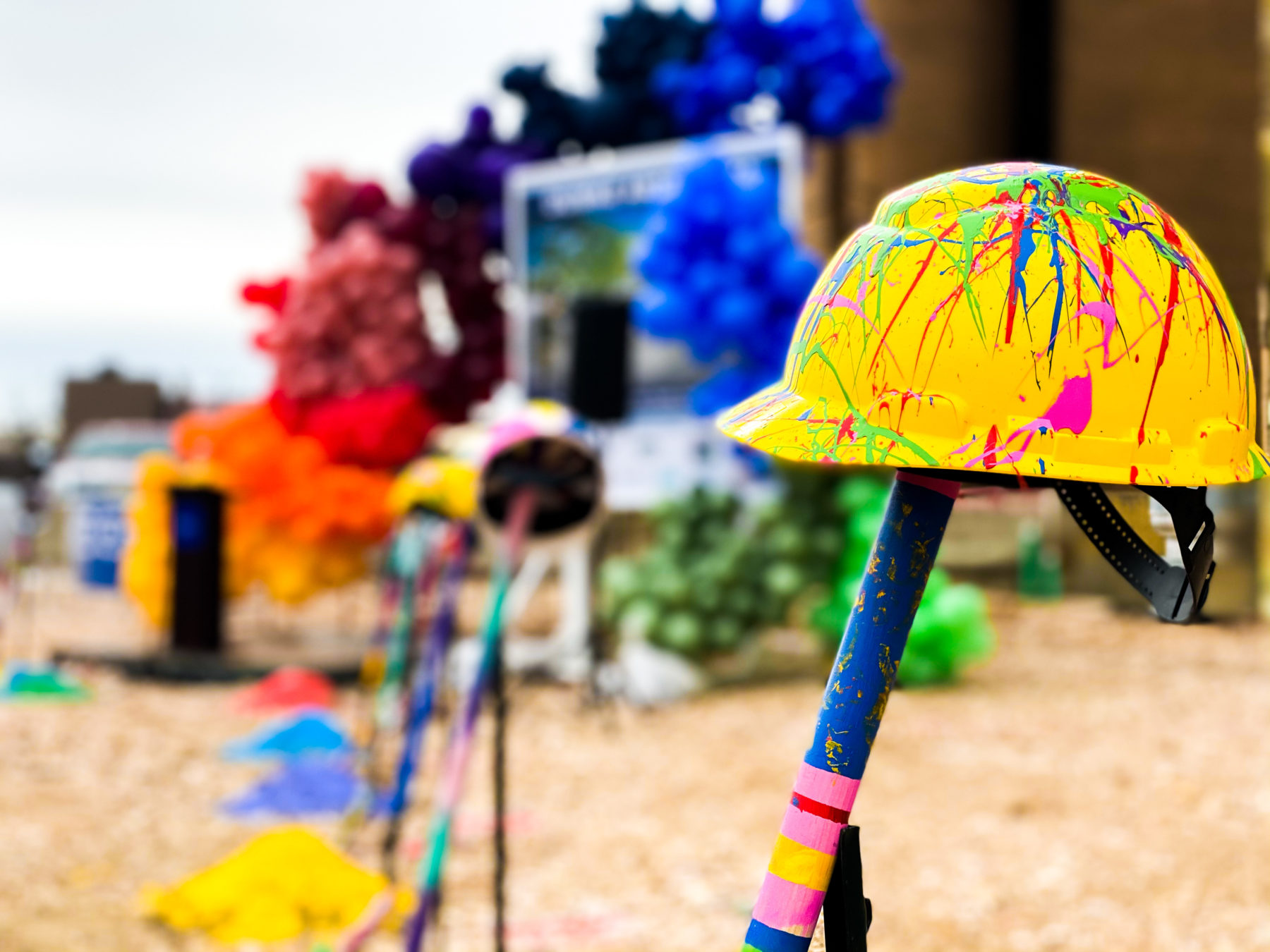 Helmet with multicolored paint on it on shovel at event grounbreaking