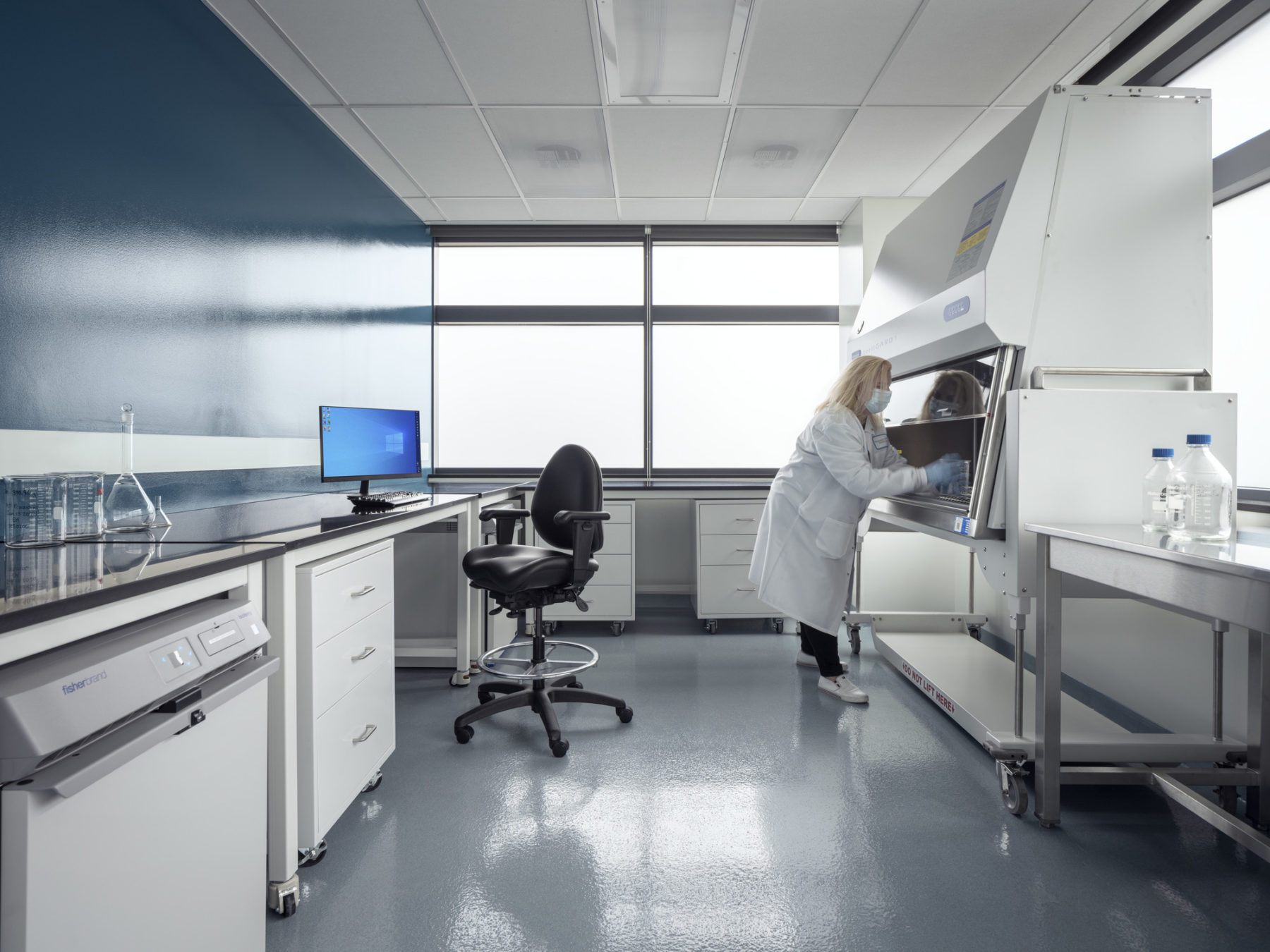 photo of woman working under ventilation hood