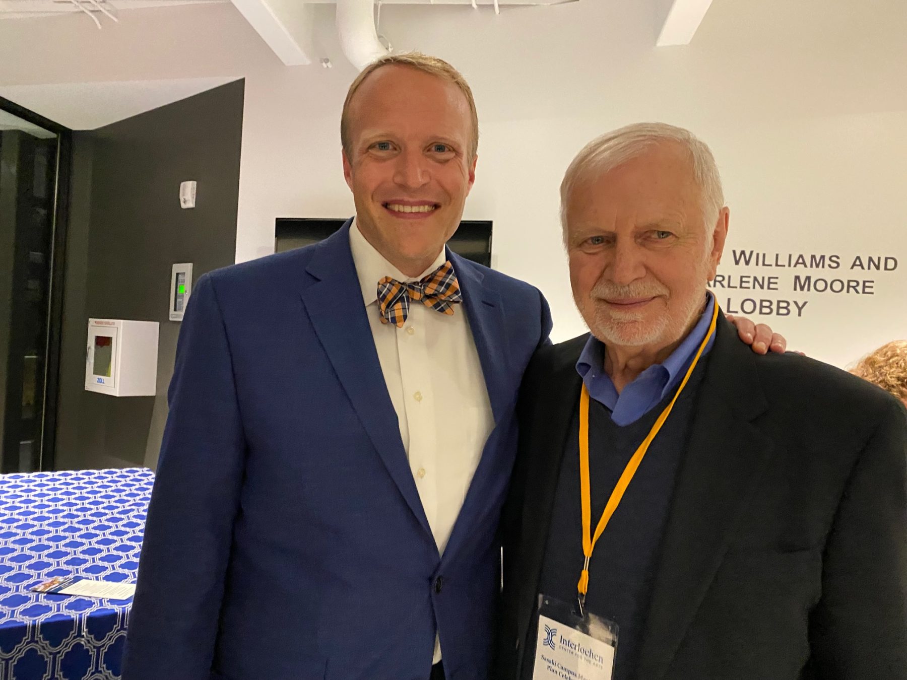 Two men pose at celebratory event