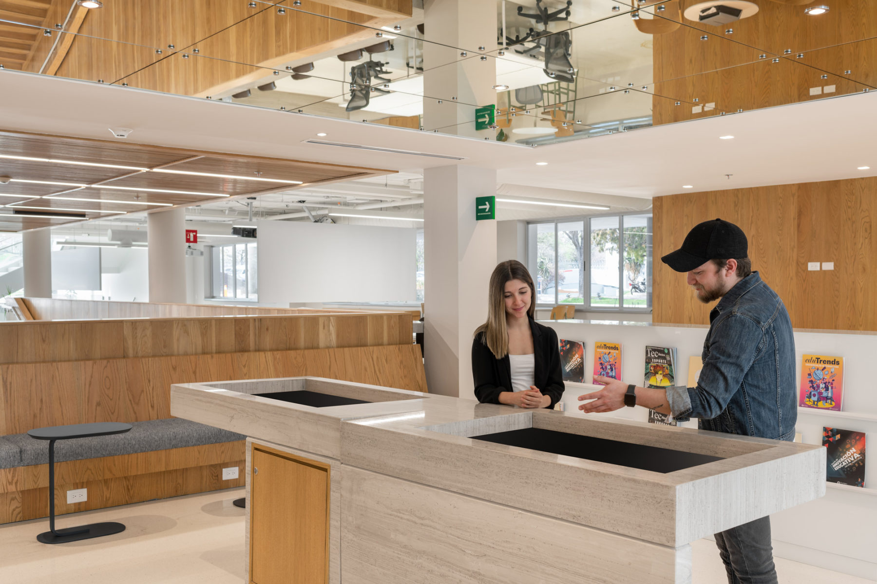Interior photo of building. Two students stand a display case looking into it.