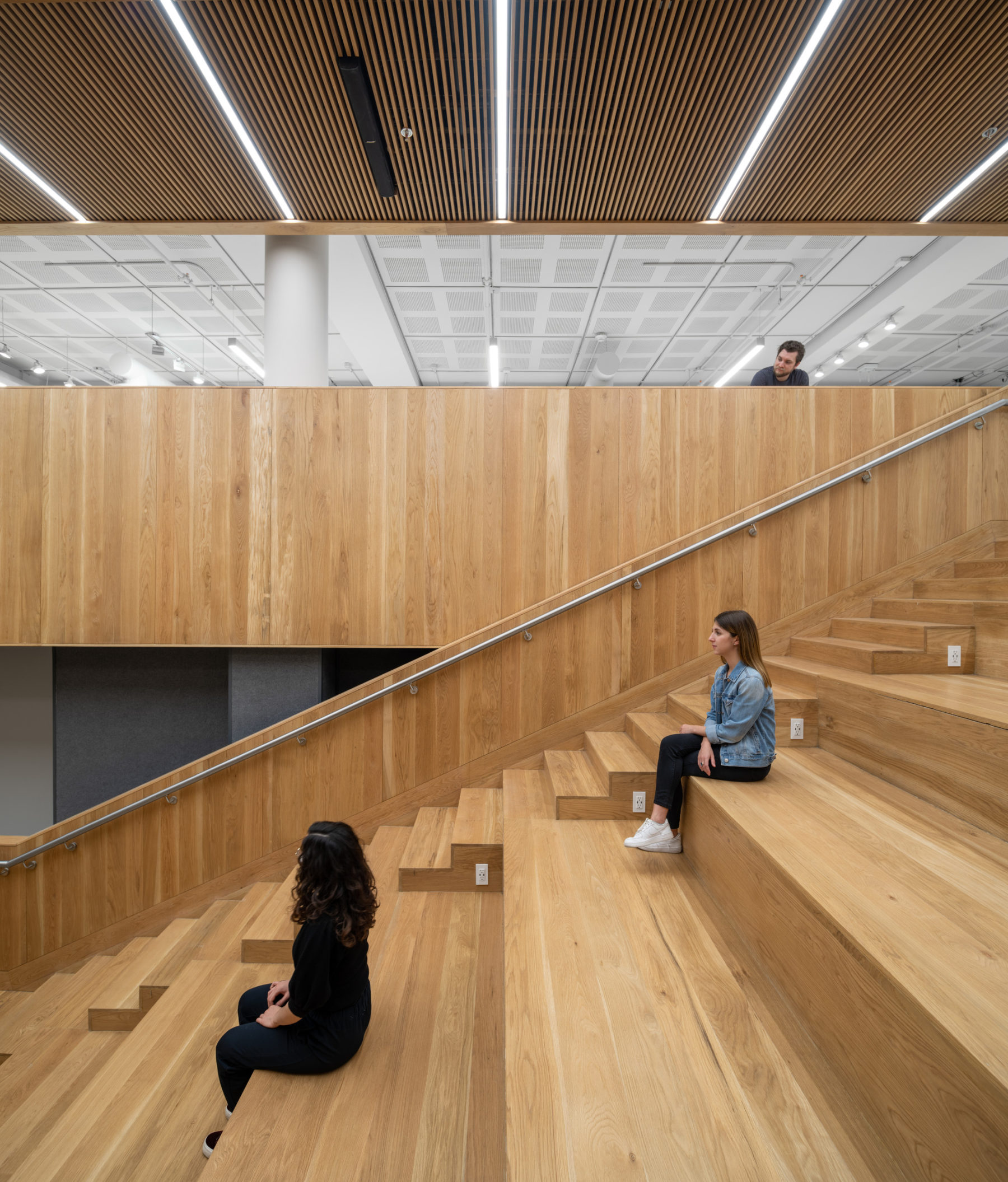 interior photo looking at side view of amphitheater with two students sitting on steps