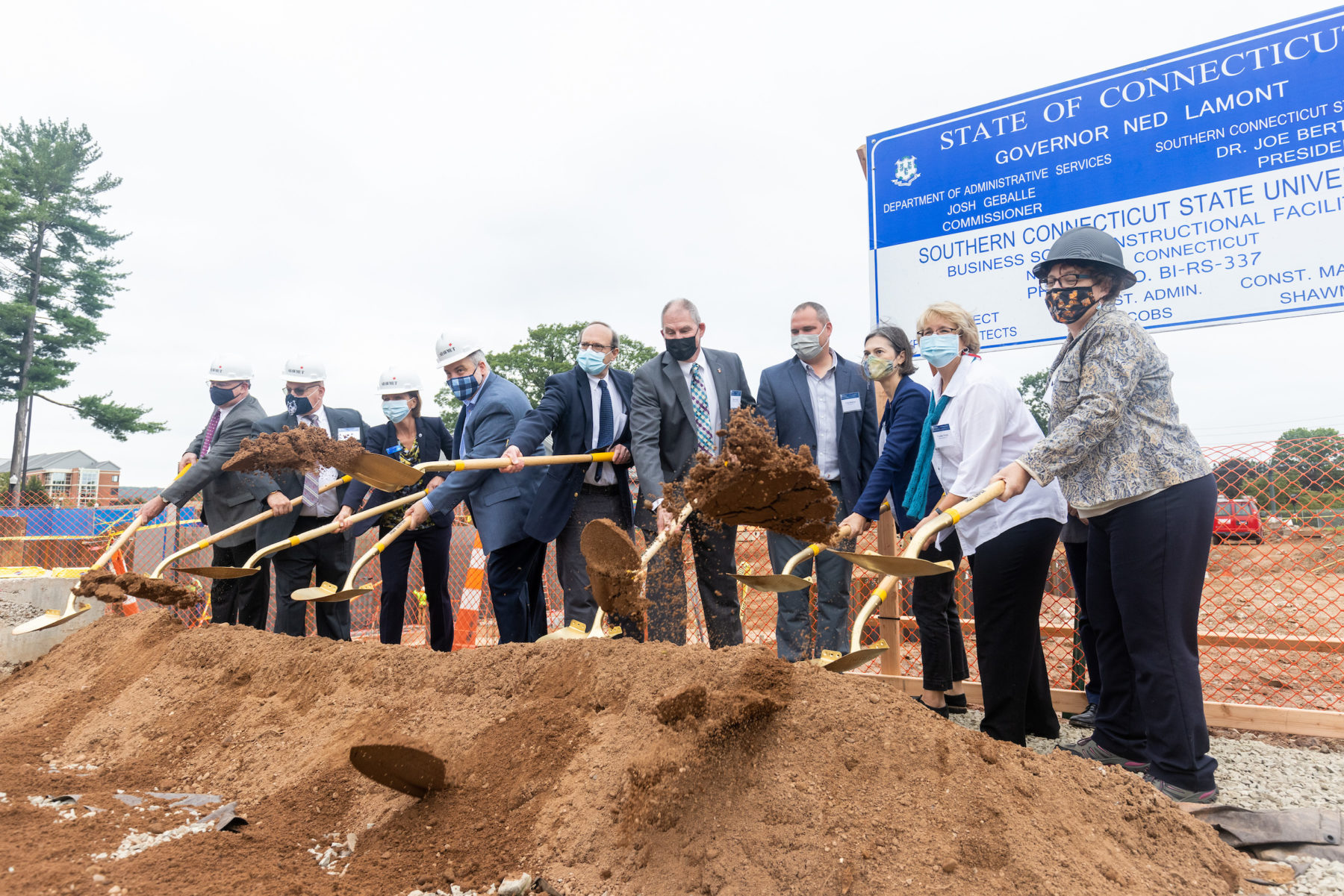 People with shovels throwing dirt in the air to celebrate the groundbreaking