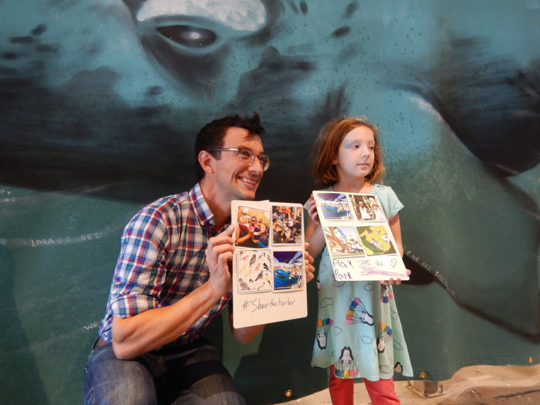 photo of father and daughter at public engagement session. they are holding mood board they created