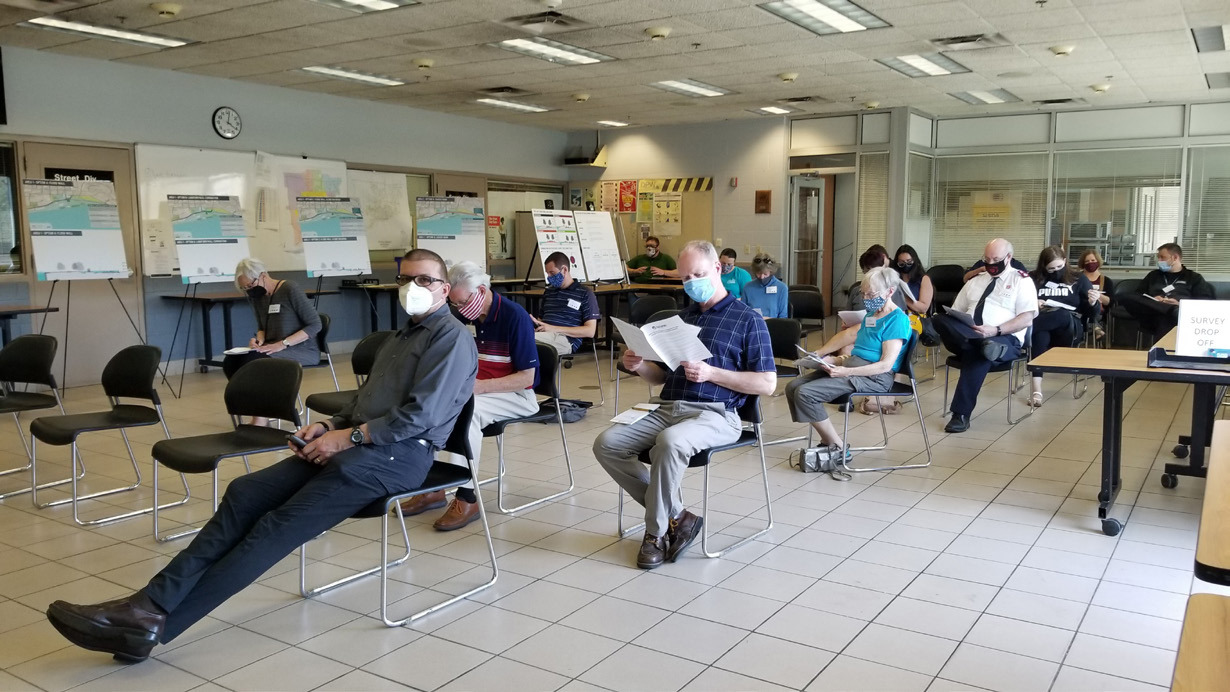 photo of public engagement session groups of masked people sitting in rows of chairs