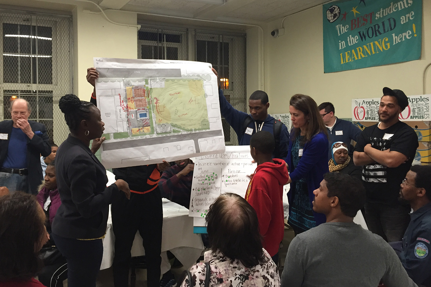 A group of people presents a diagram on a poster to community members