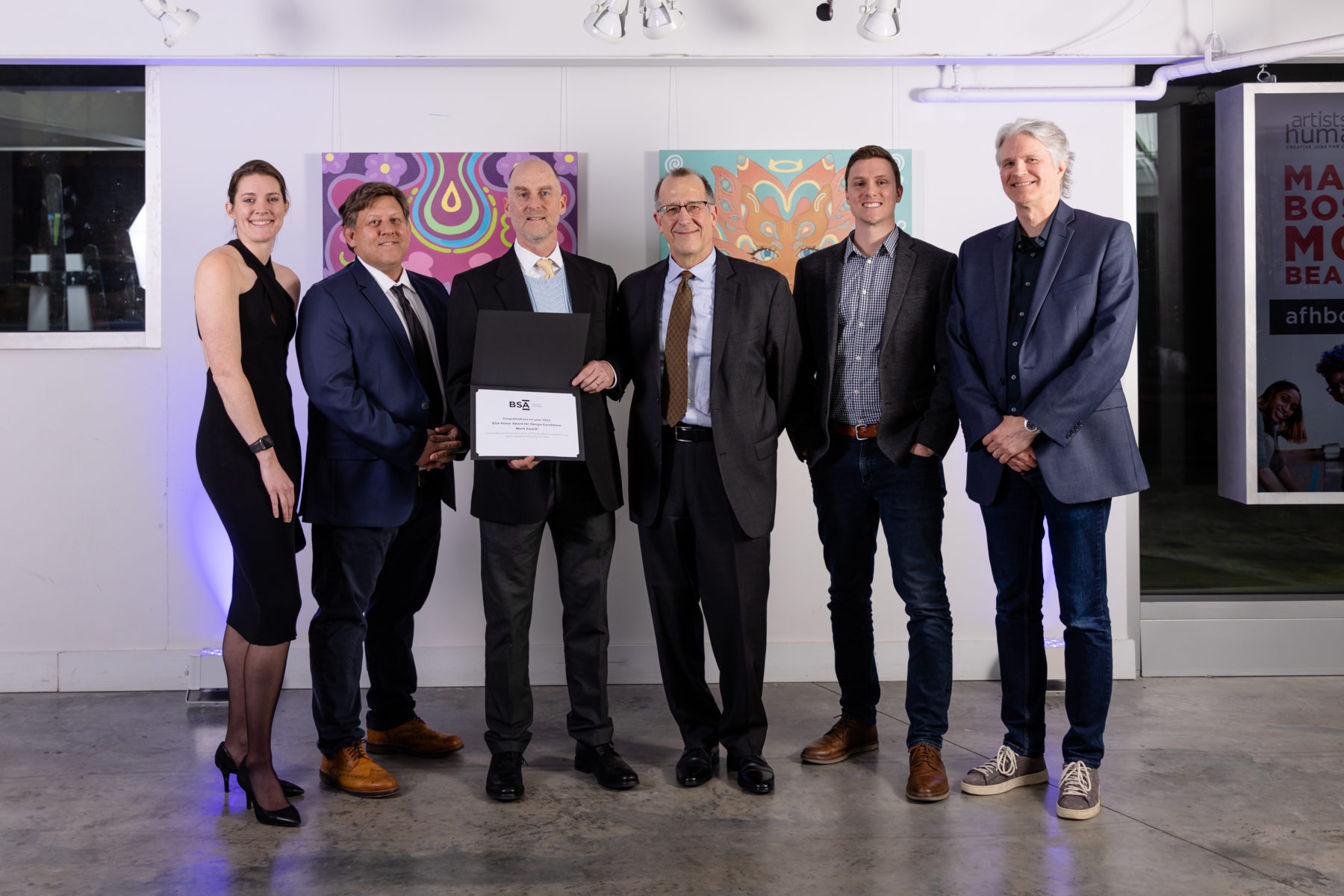 Seven people dressed up smiling holding their award